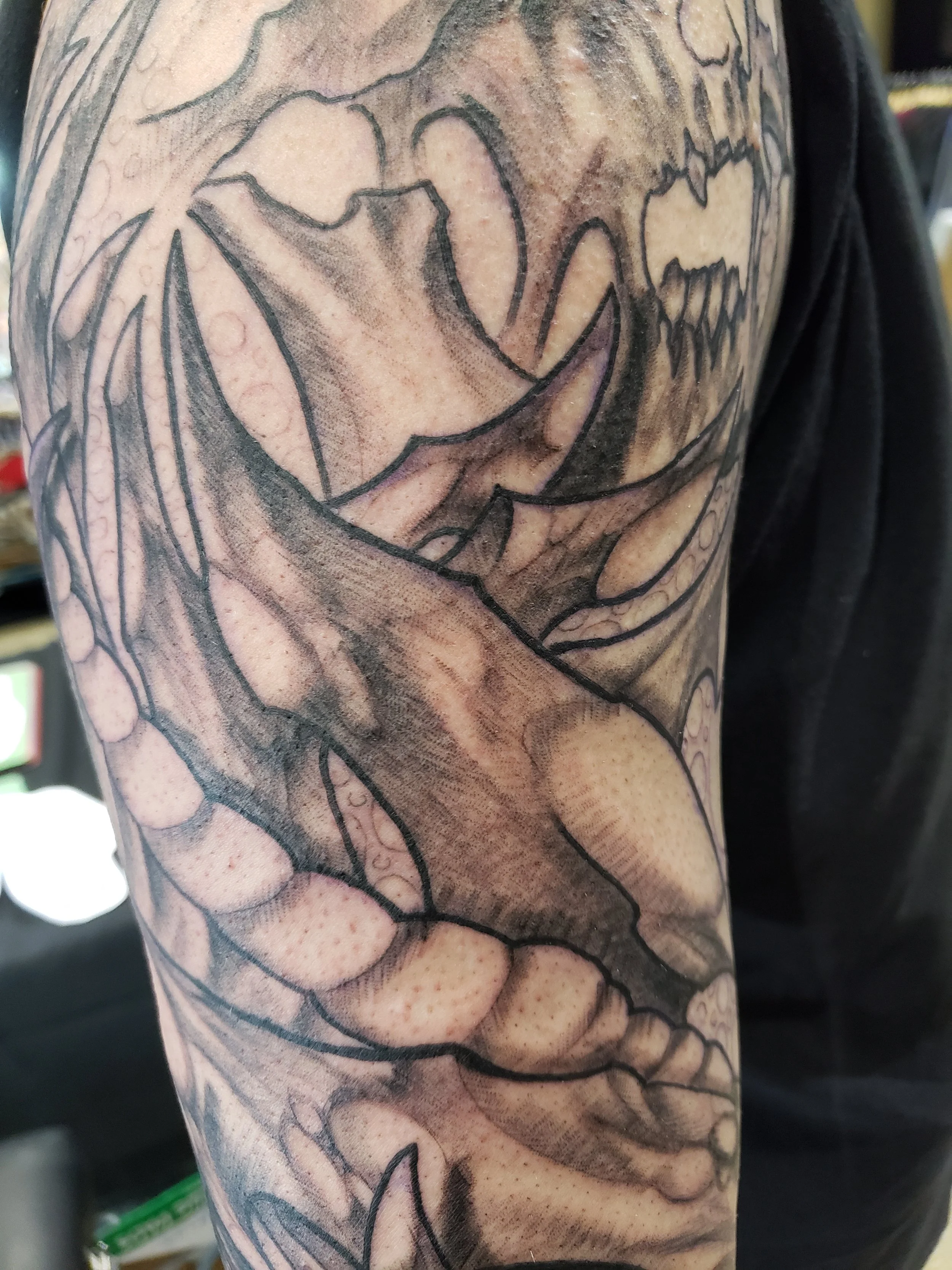 Close-up of a detailed black and gray tattoo of a spider web on a person's arm.