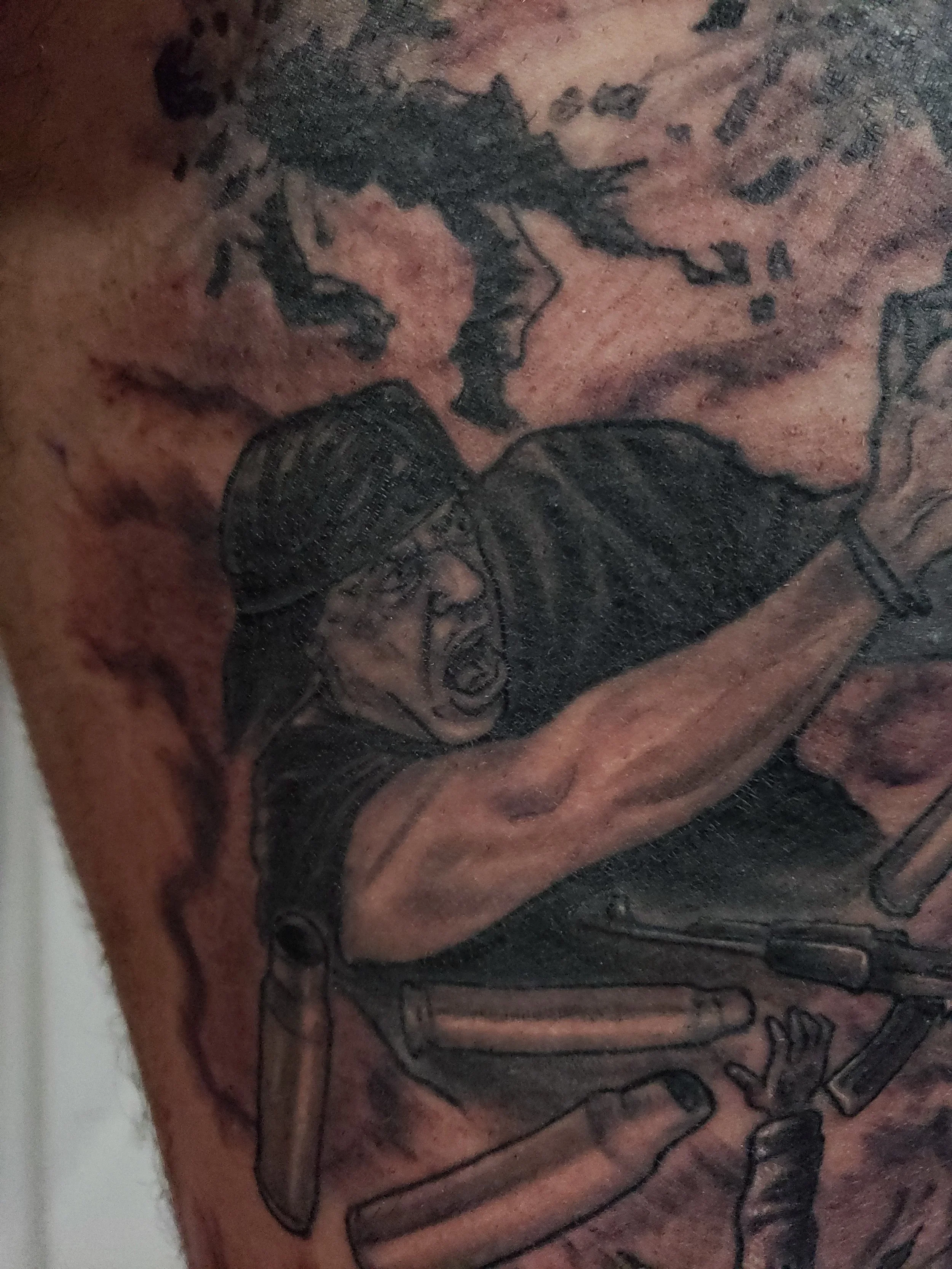 A close-up image of a tattoo on skin, featuring an outlined skeleton holding a microphone.