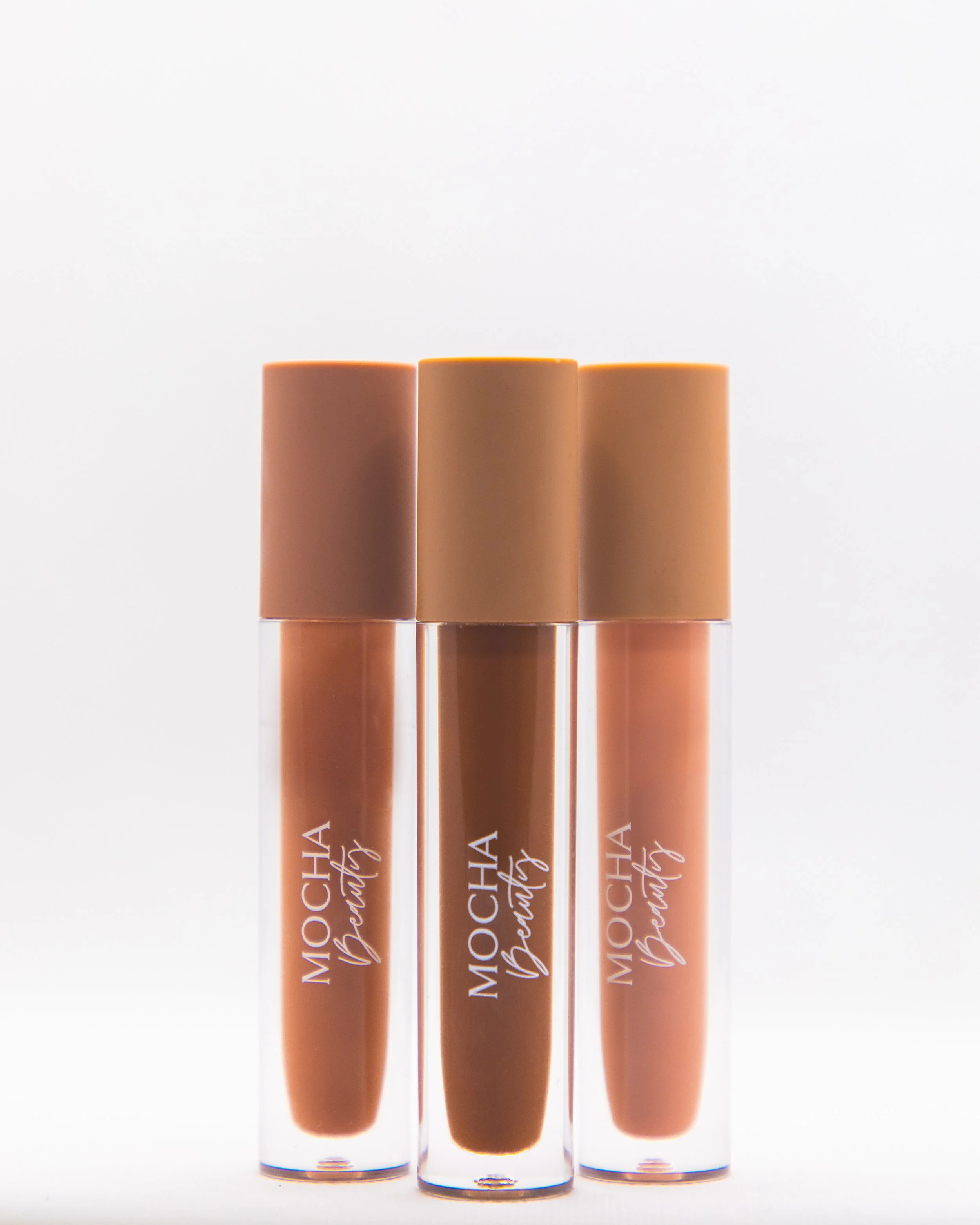 Three lip gloss tubes with nude shades, labeled 'MOCHA Beauty', standing upright against a white background.