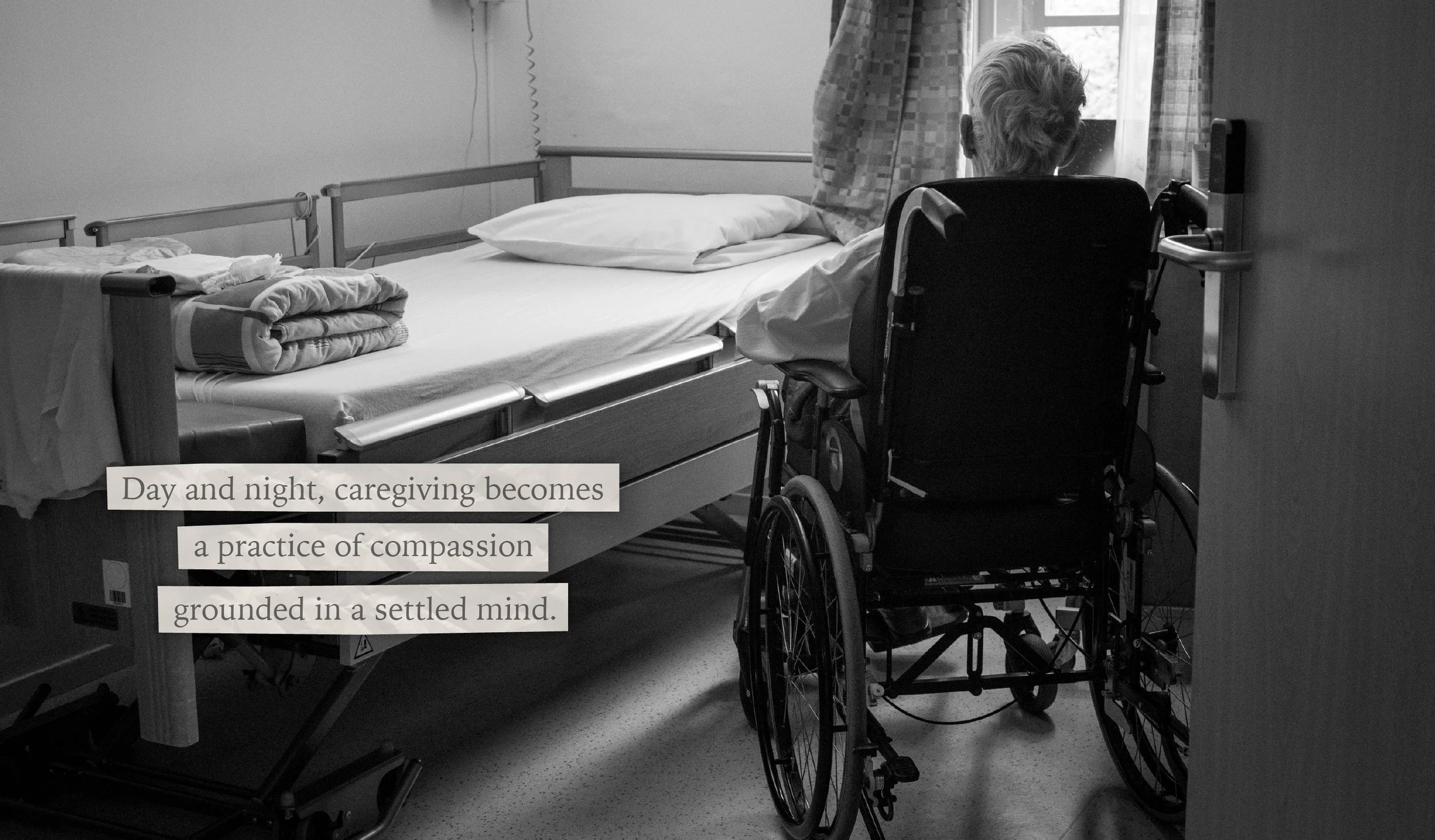 A man sits in a wheelchair looking out the window