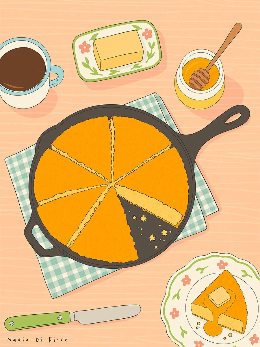 Overhead illustration of sliced cornbread in a cast-iron skillet on a blue-and-white checkered cloth, with a slice topped with butter and honey on a floral plate, a coffee mug, butter dish, honey pot and butter knife on a wooden table.
