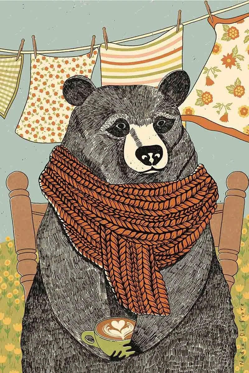 Illustration of a black bear wearing an orange knitted scarf, sitting in a rocking chair with a cappuccino, with patterned tea towels hanging on a clothesline, contemporary folk illustration.