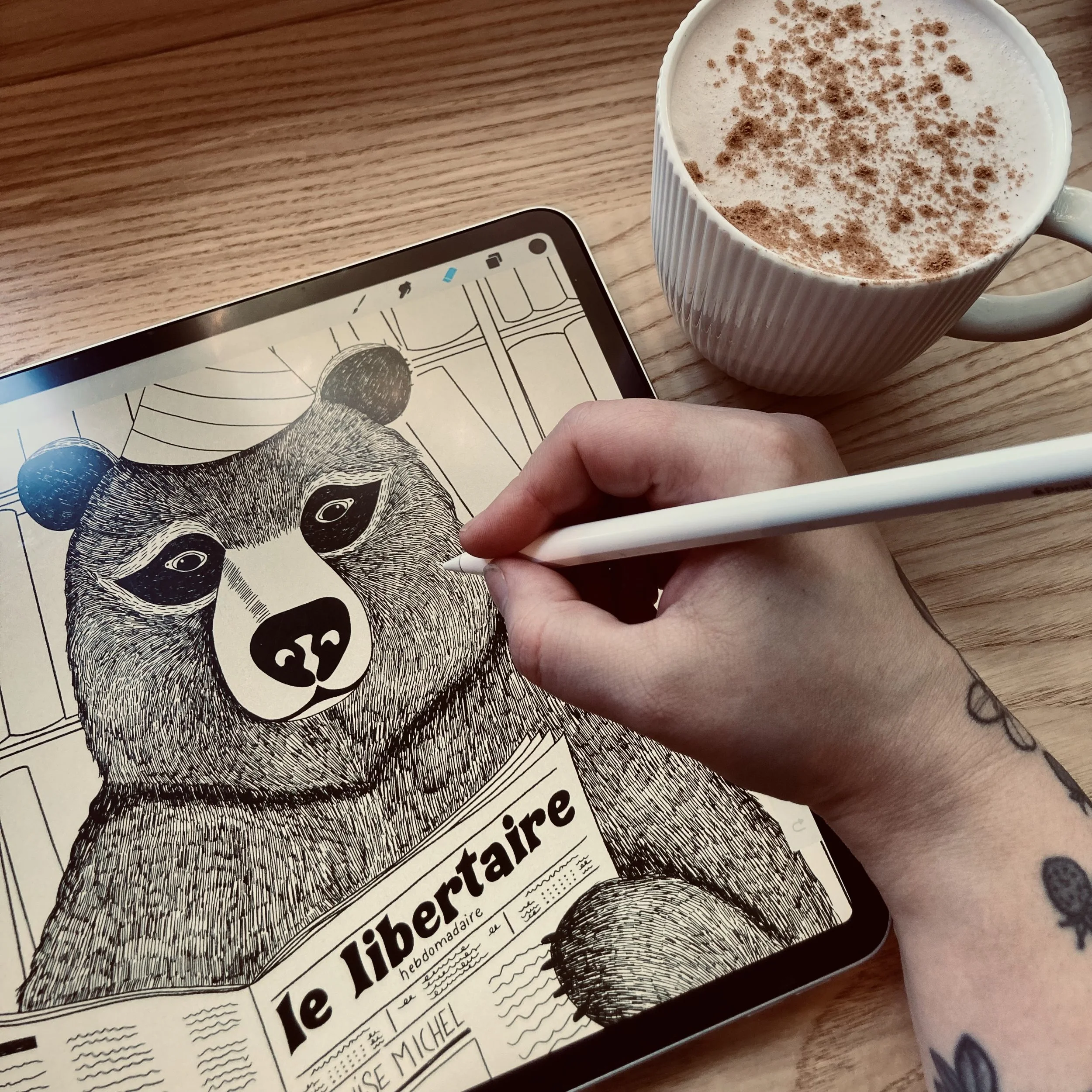 Close-up of contemporary folk Illustrator Nadia Di Fiore’s hand drawing a bear on a tablet.