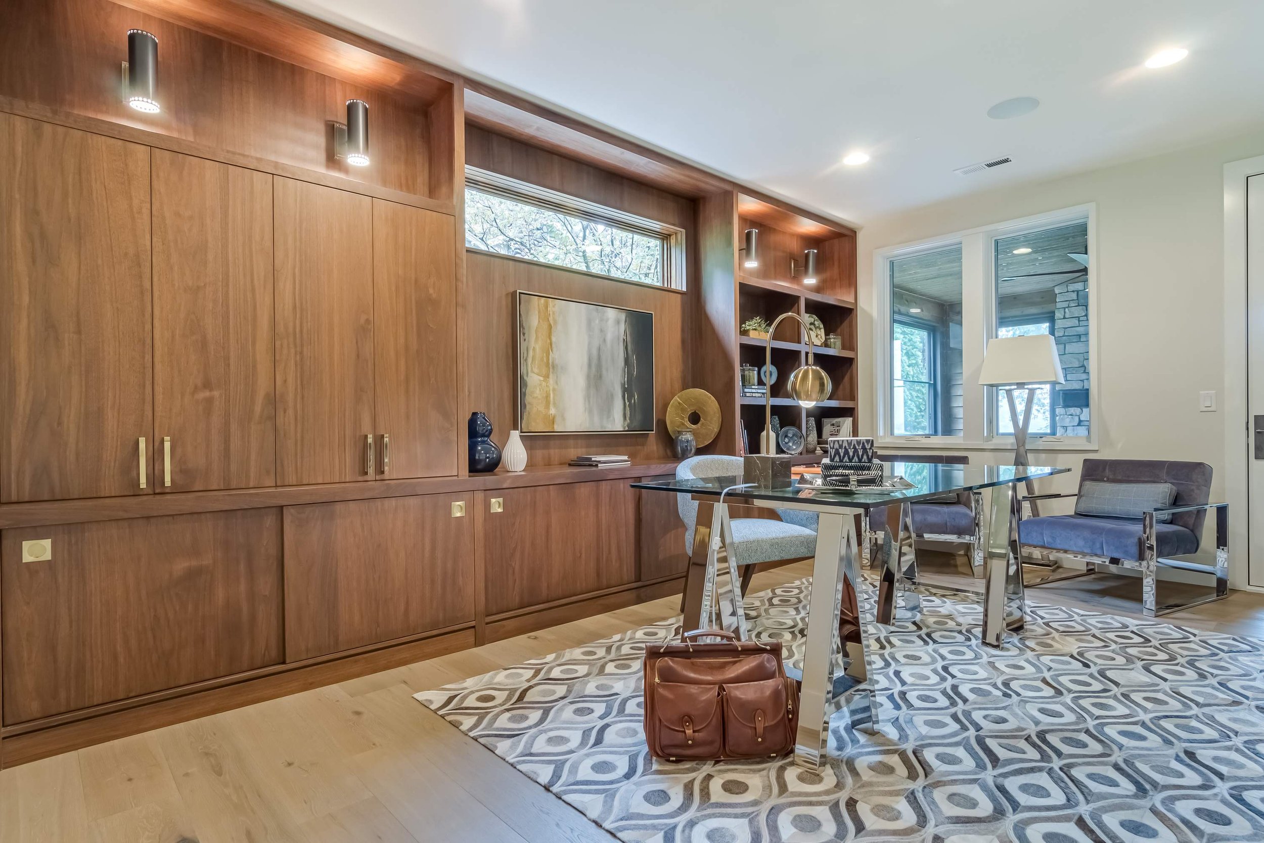 Room with custom home office cabinets and glass desk