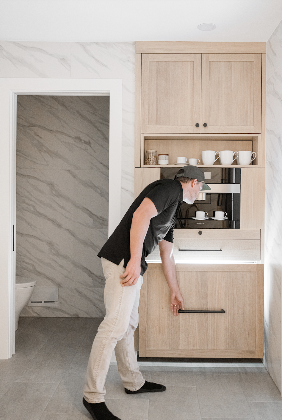 Floor-to-ceiling wood cabinets with integrated coffee station and storage
