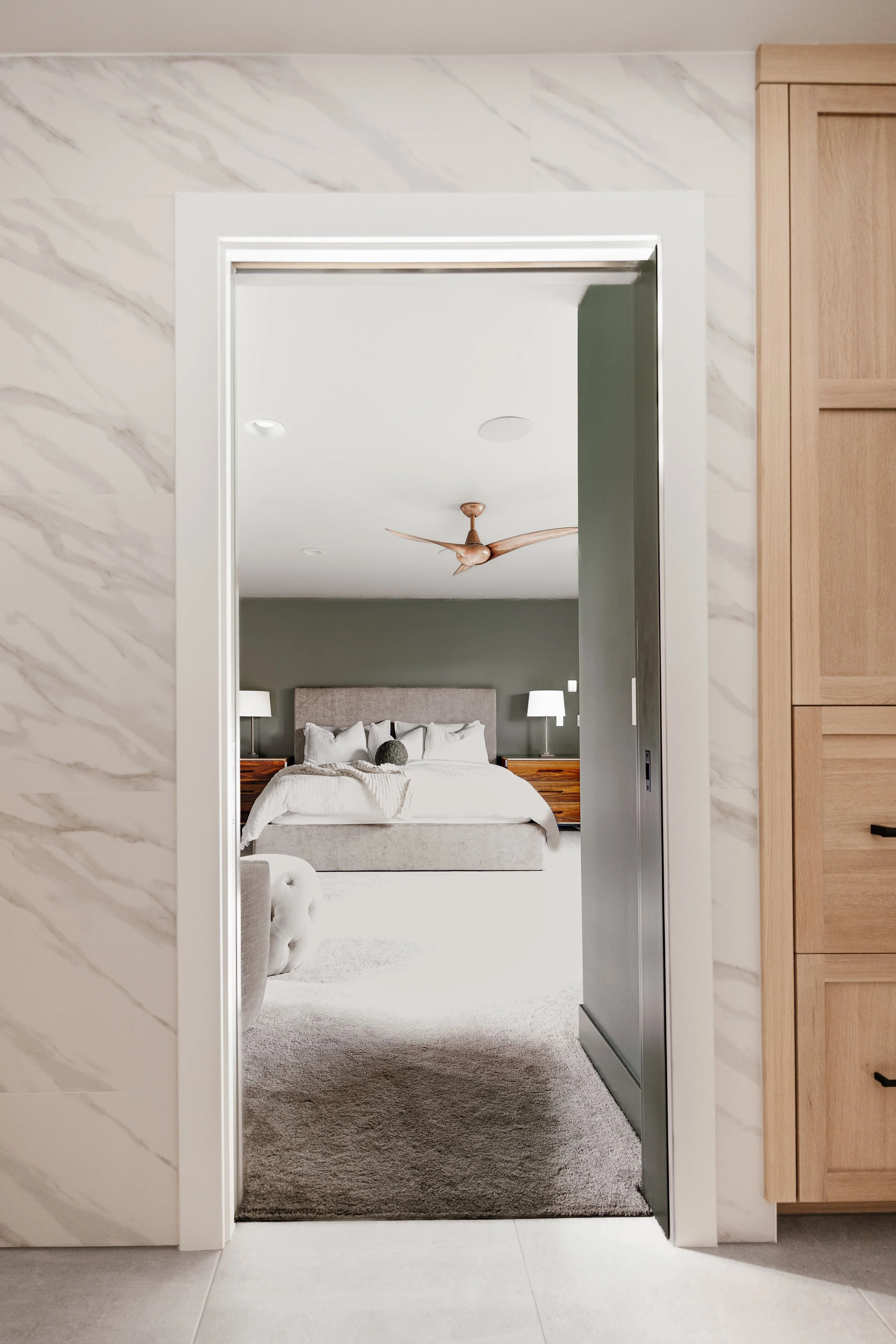 View through the doorway into the bedroom with custom wood cabinets and built-in storage along the wall