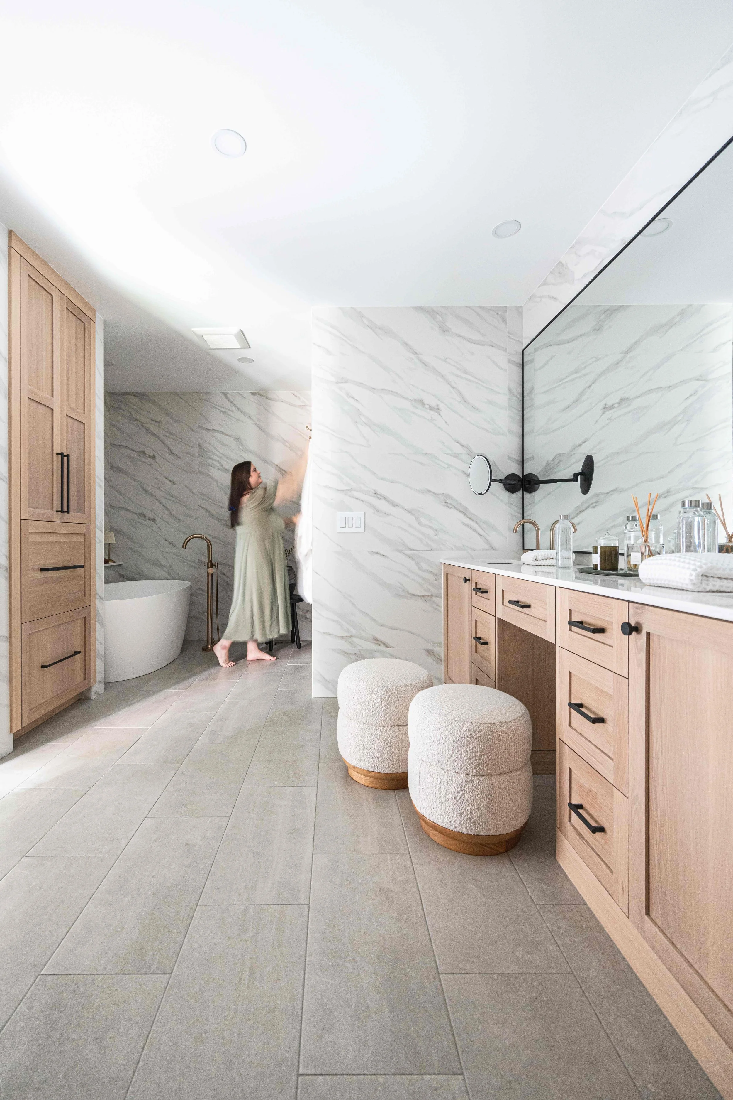 a photo of Kayla Schultz, designer of construction2style hanging towels in a custom bathroom with custom bathroom cabinets by Sean's cabinetry