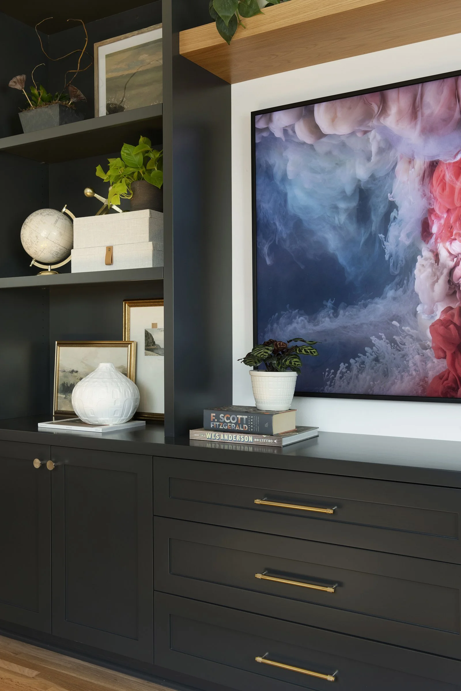 Modern black cabinets with brass hardware and display shelving