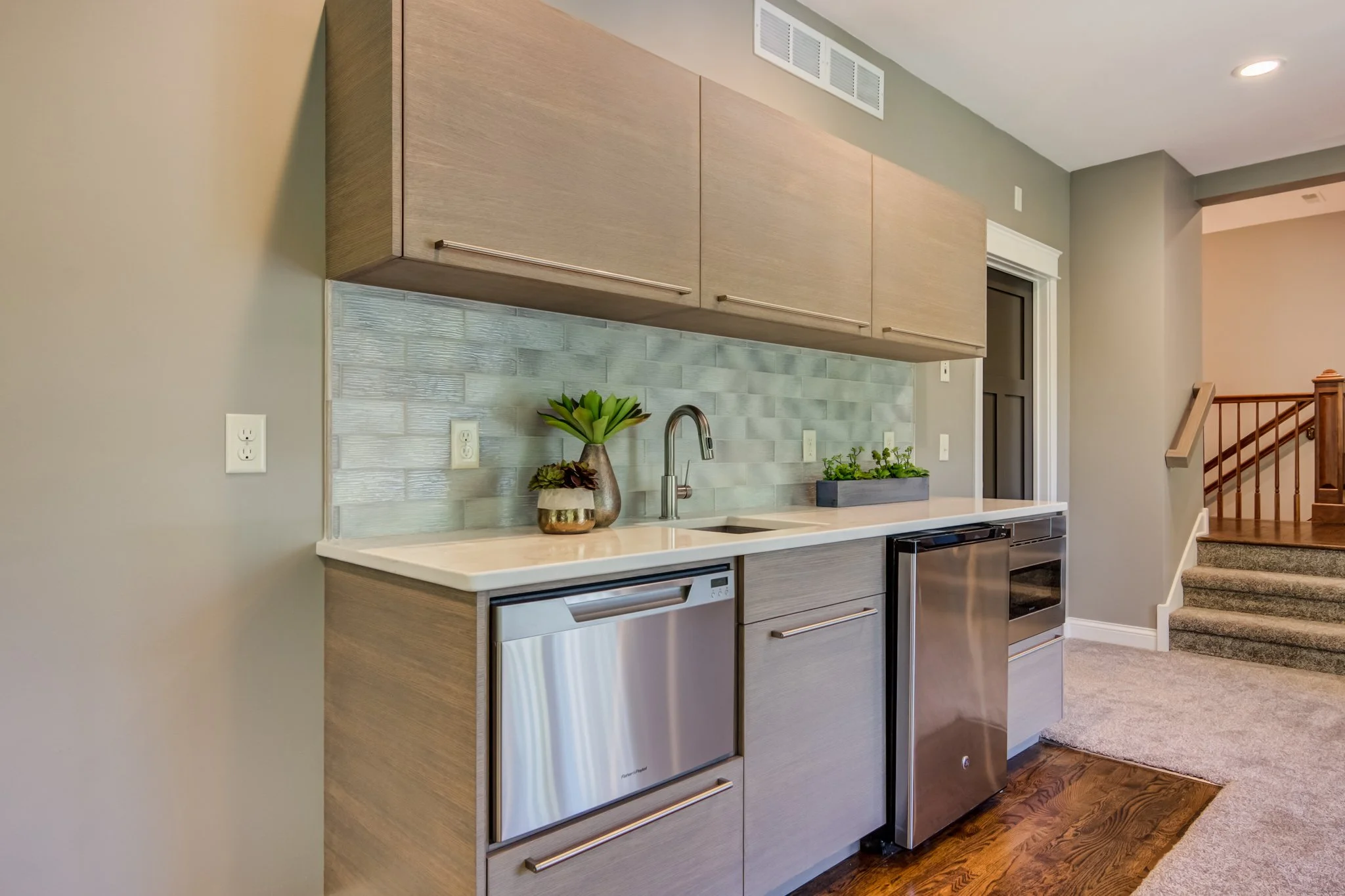wet bar with three in vertical lift up cabinet doors in rift white oak with a custom gray stain