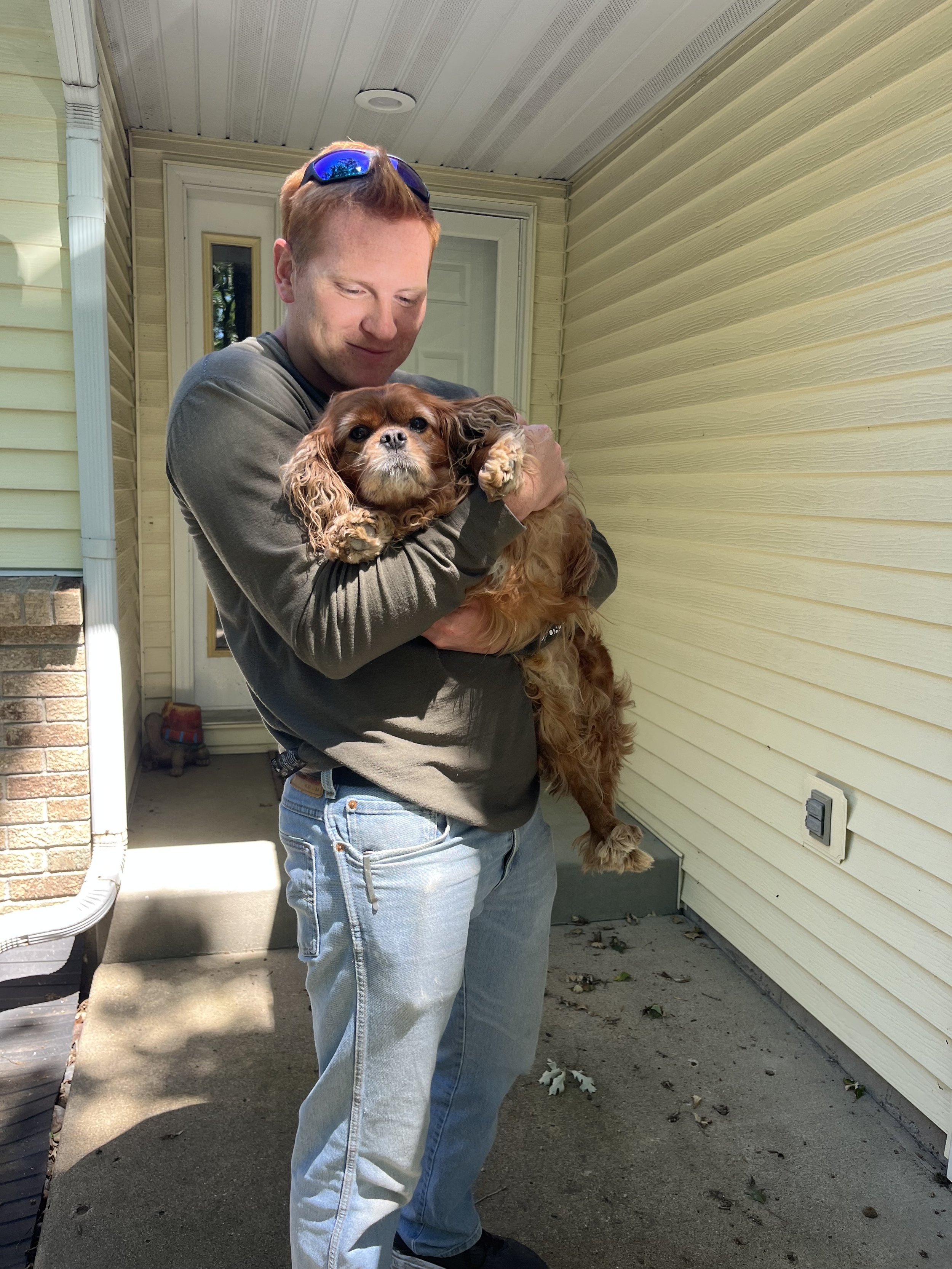 Sam Miller of Sean's Cabinetry is holding a puppy