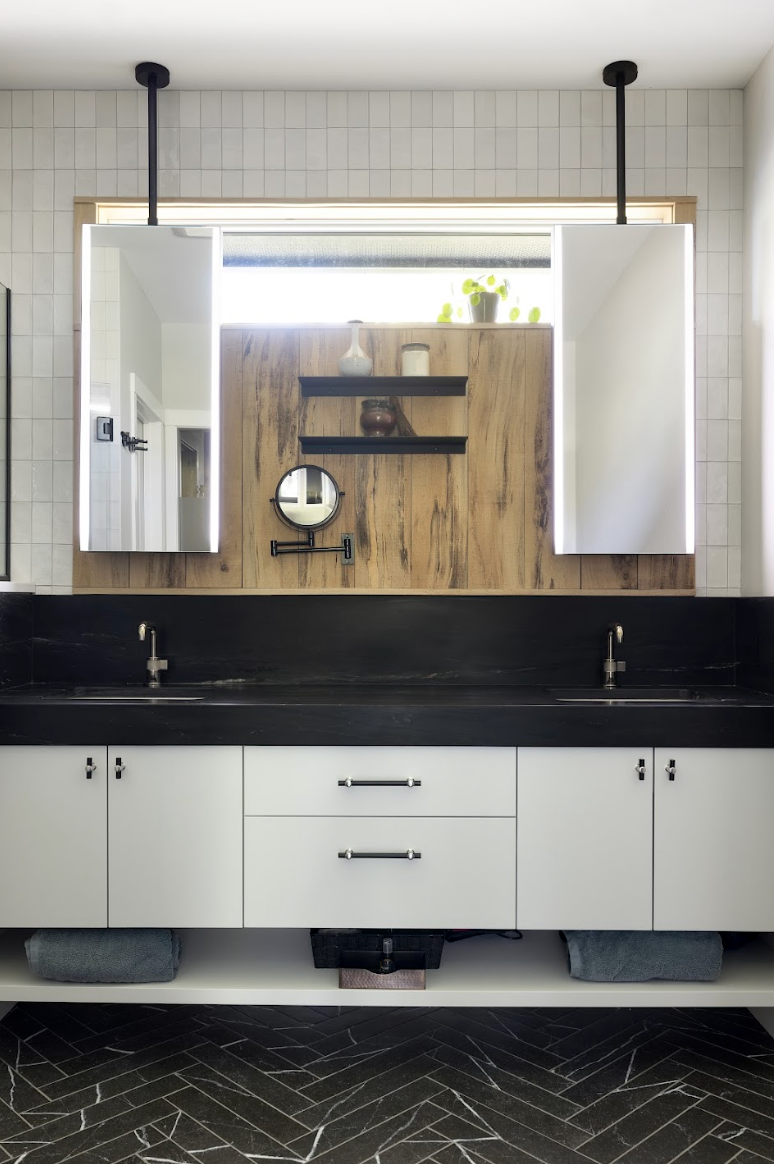 Modern custom bathroom cabinetry featuring flat-panel drawers, matte black countertop, wood accent wall, and open shelving