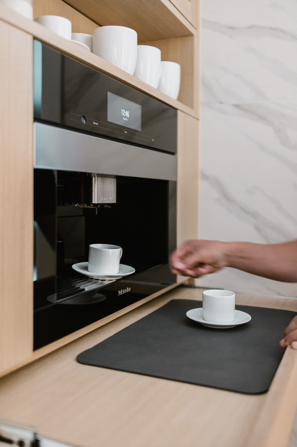 Light wood cabinets with pull-out shelf and built-in coffee station