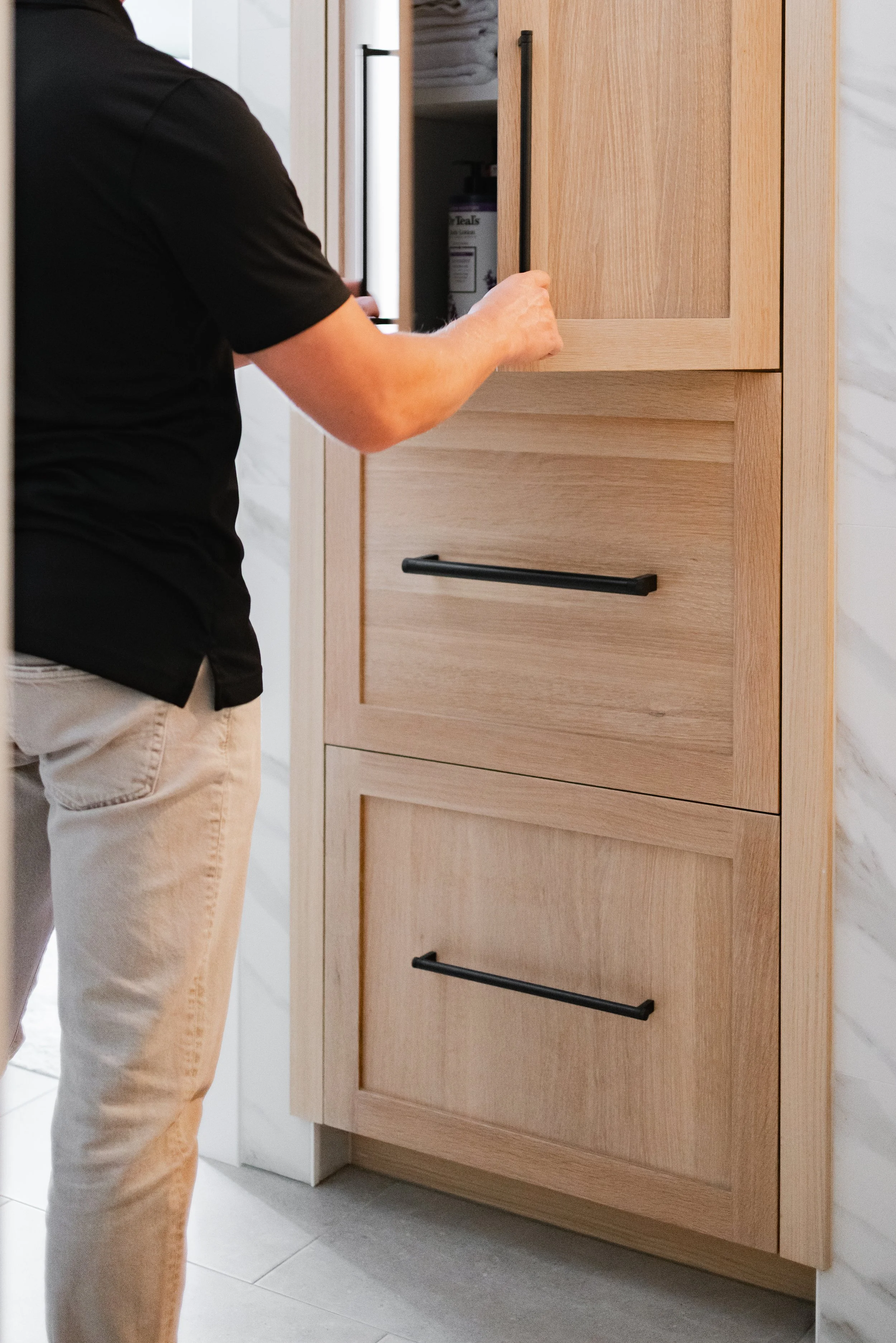 Custom wood bathroom cabinets with drawers and upper storage in use