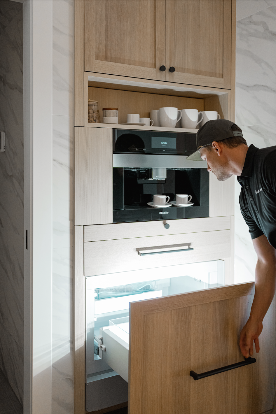 Built-in wood cabinets with integrated coffee machine and pull-out refrigerated drawer being opened.