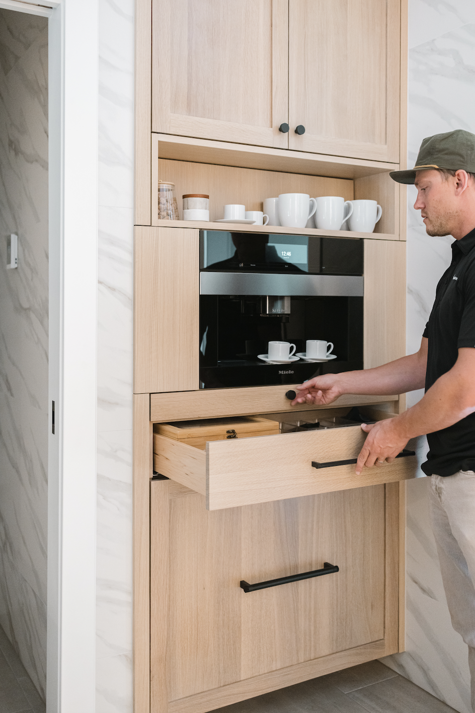 Light wood cabinets with pull-out drawer and integrated coffee machine storage