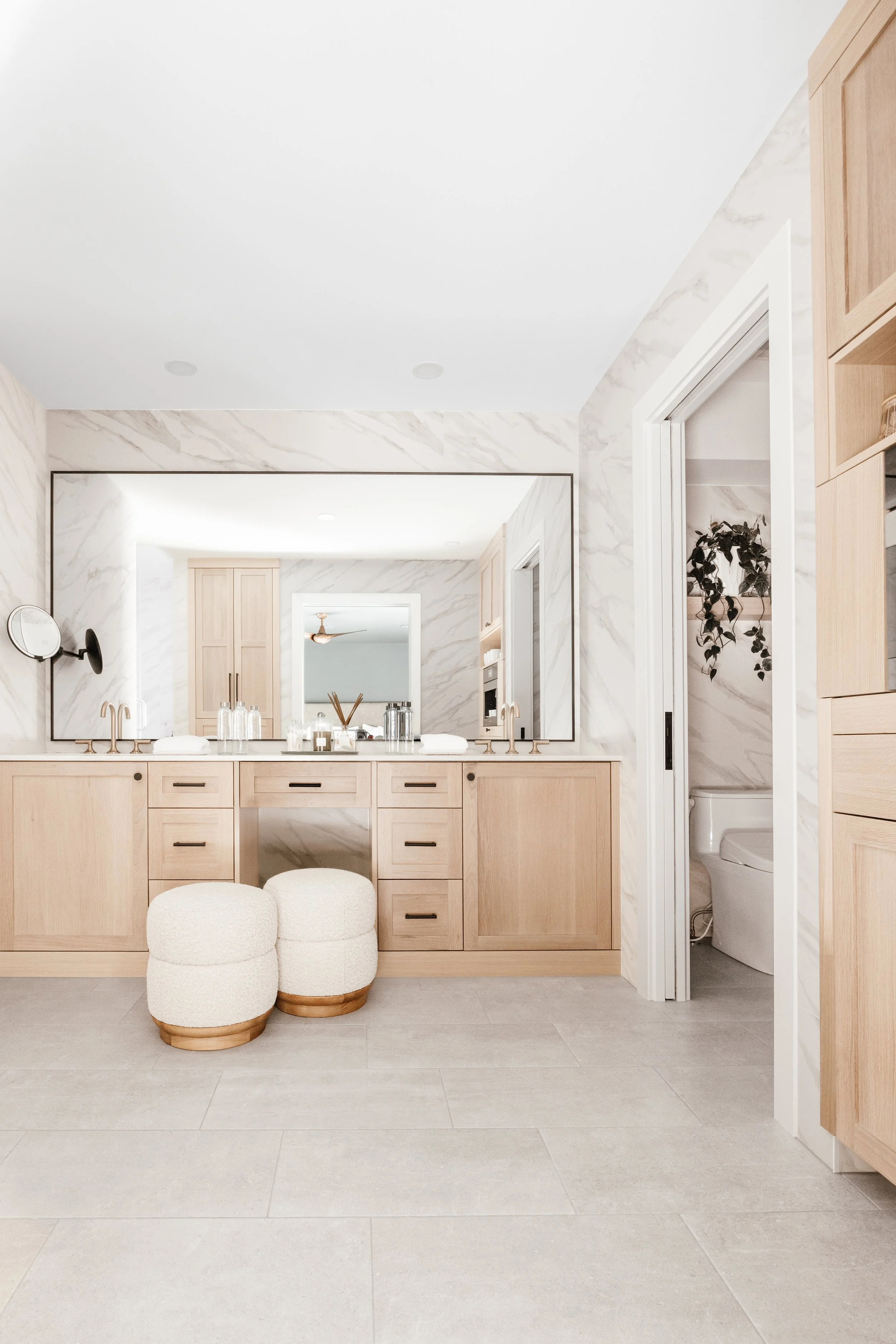 Modern bathroom cabinets in light wood with a double vanity, drawer storage, and a large mirror