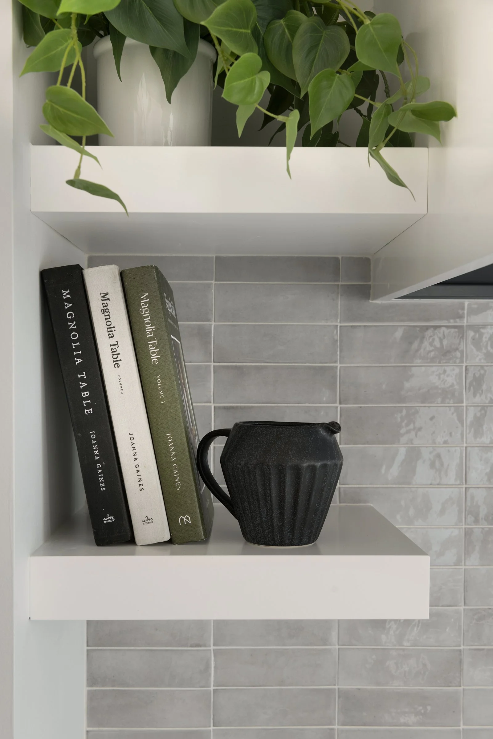 Close-up of floating open shelves styled with books and greenery.