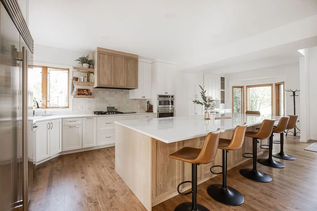 White and Wood Kitchen Cabinets in l-shape kitchen with a large island and five swivel counter stools