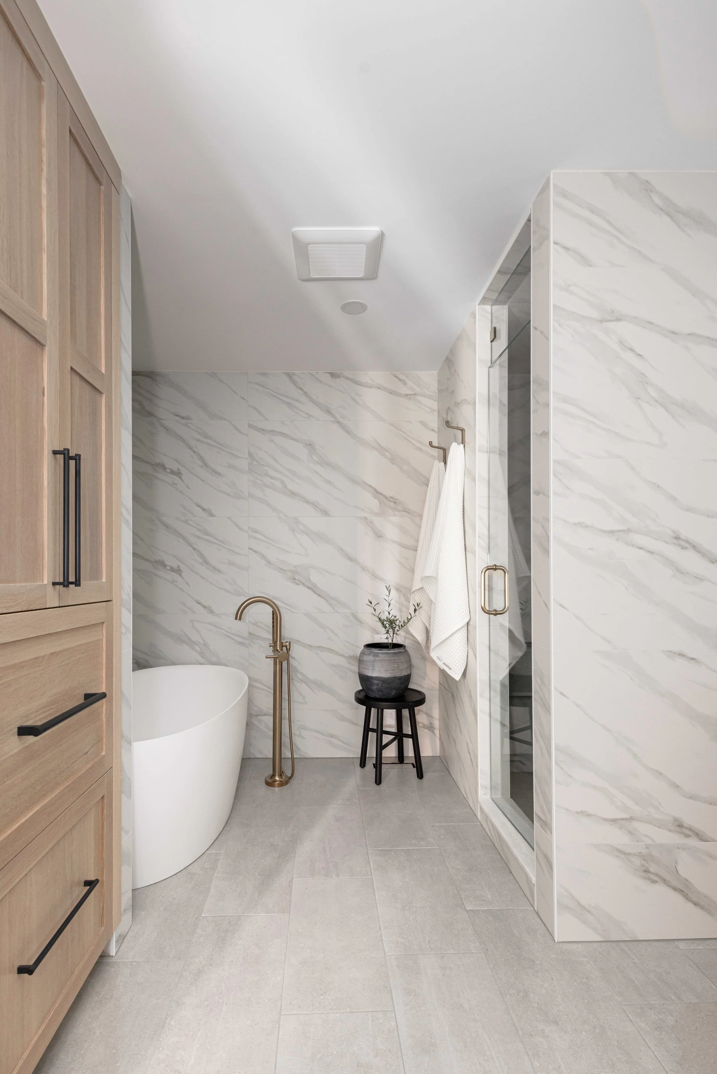 a photo of a beautiful bathroom with a free standing tub and a custom linen cabinet