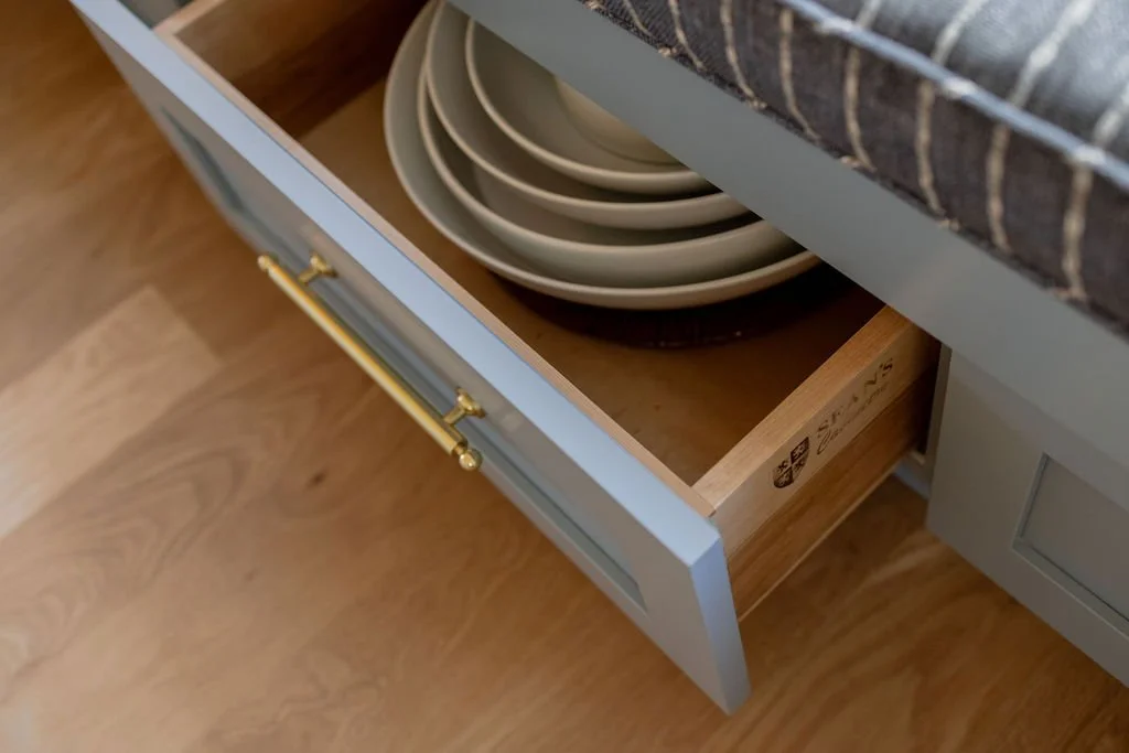 porcelain bowls stored in a drawer in a bay window bench | Sean's Cabinetry