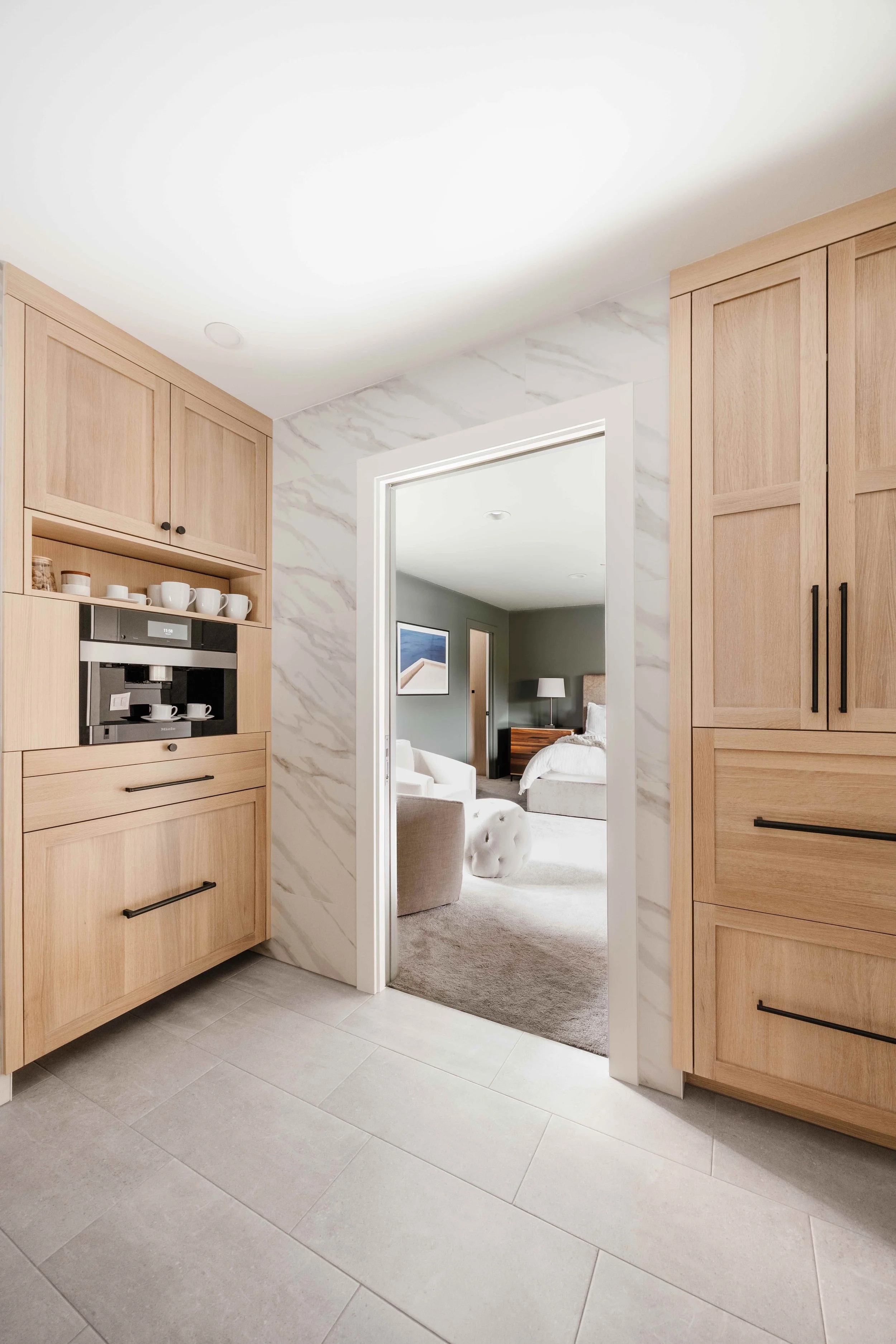 a photo of custom bathroom cabinets in a primary suite with a built in coffee station cabinet