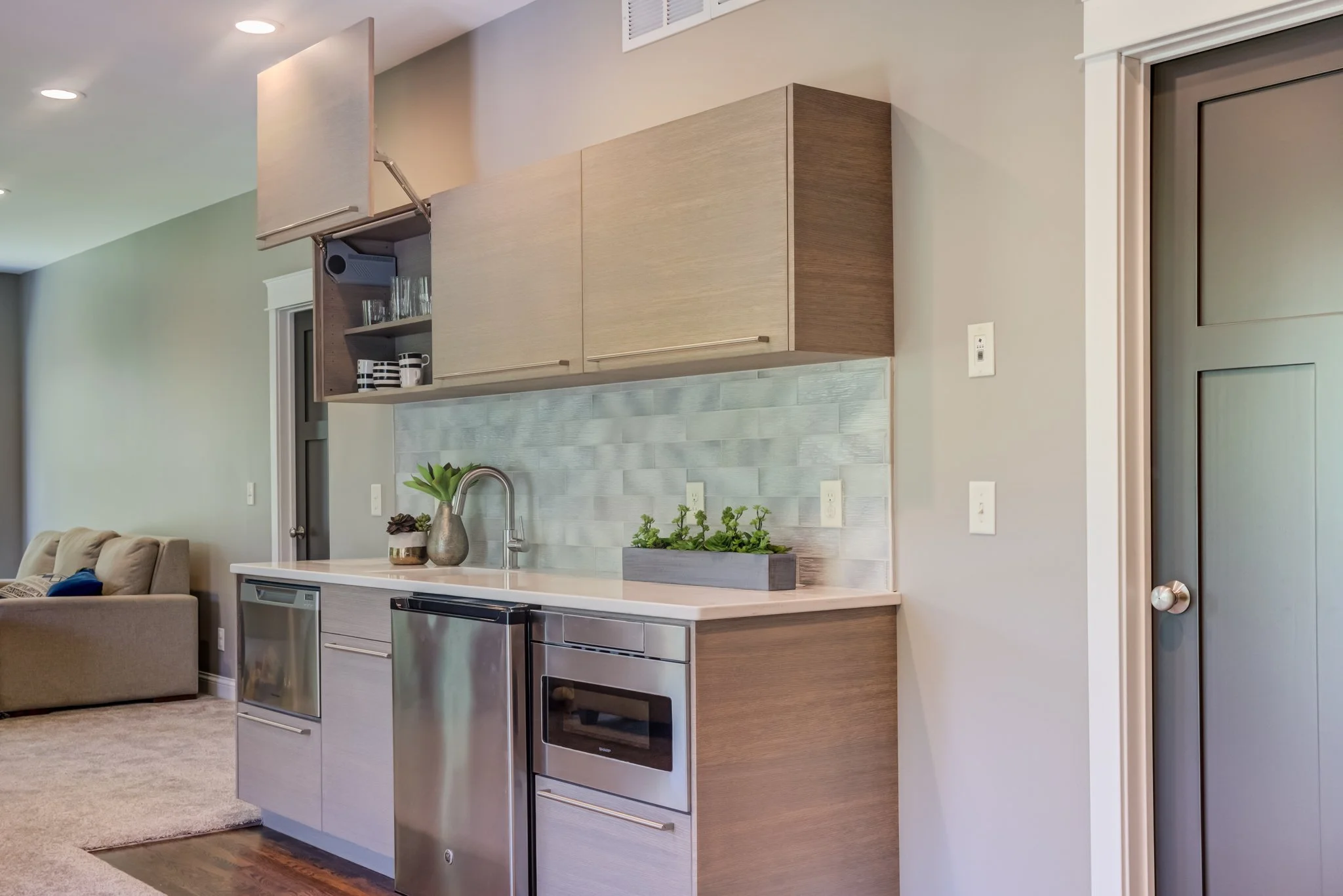 a photo of a living room wet bar with an open Vertical Lift Up Cabinet Door and built in appliances