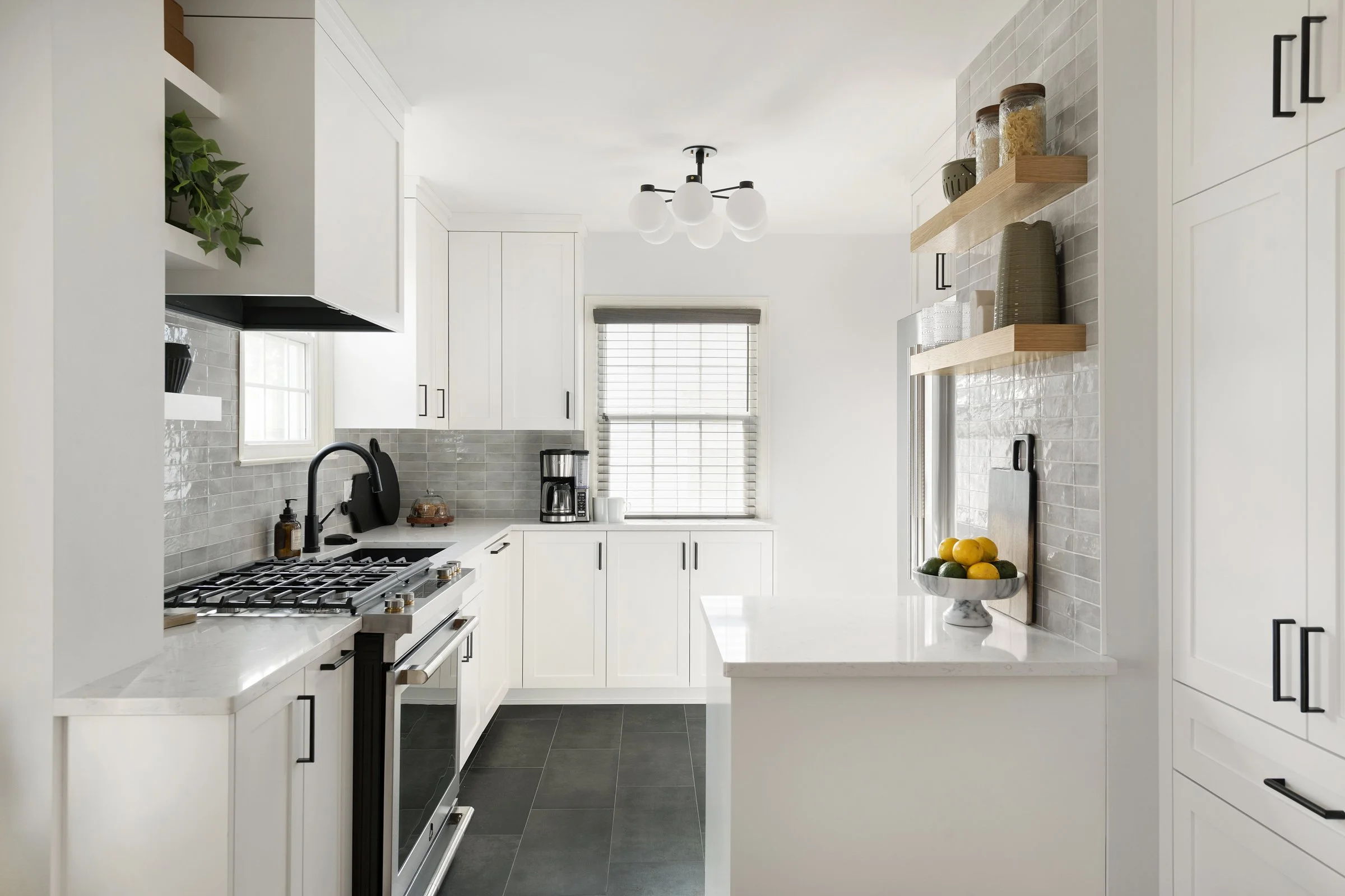 Bright kitchen with white cabinets, black hardware, and a peninsula overlooking the cooking area