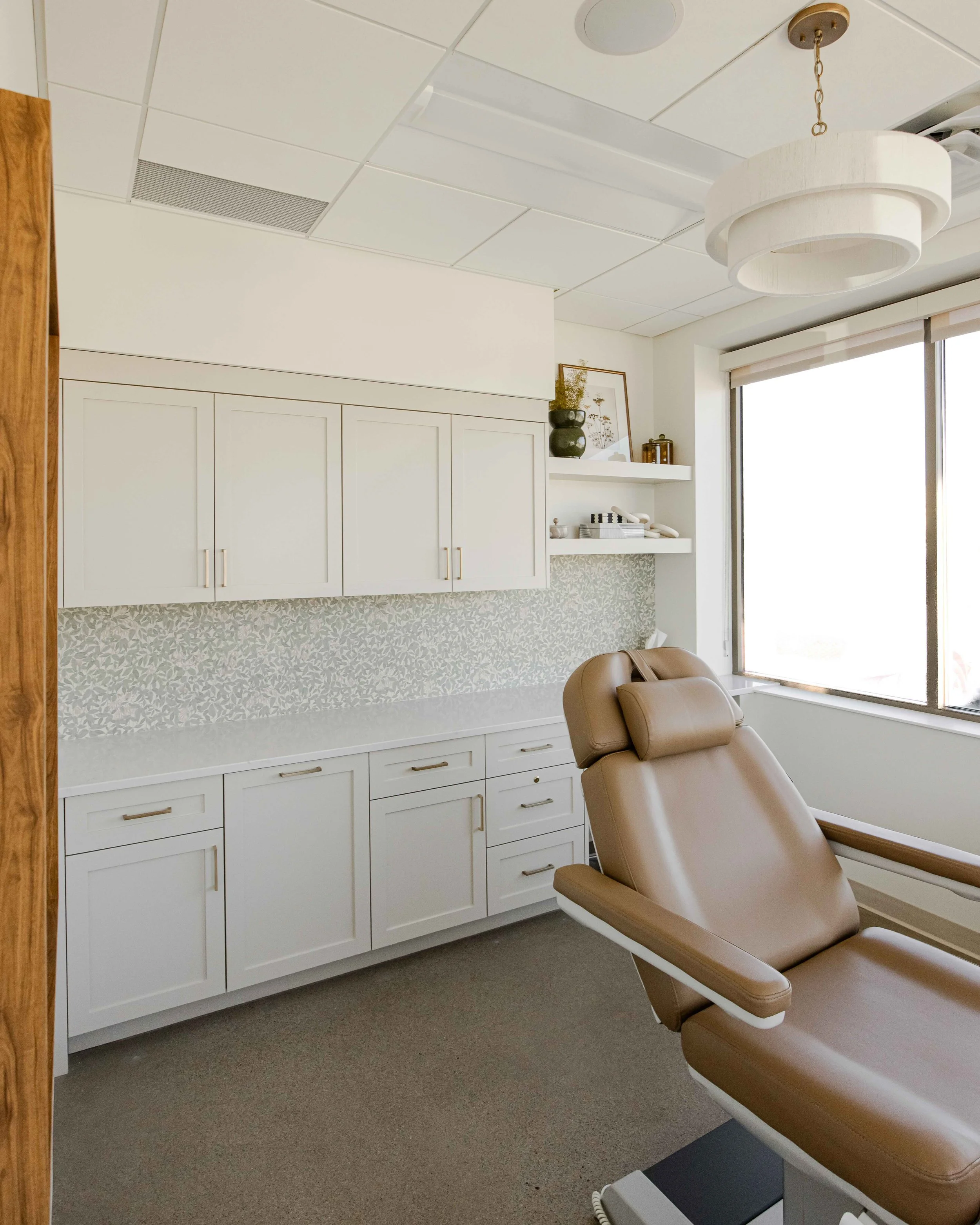 custom commercial cabinets with a large treatment chair in a laser room at Remedy Wellness | Sean's Cabinetry