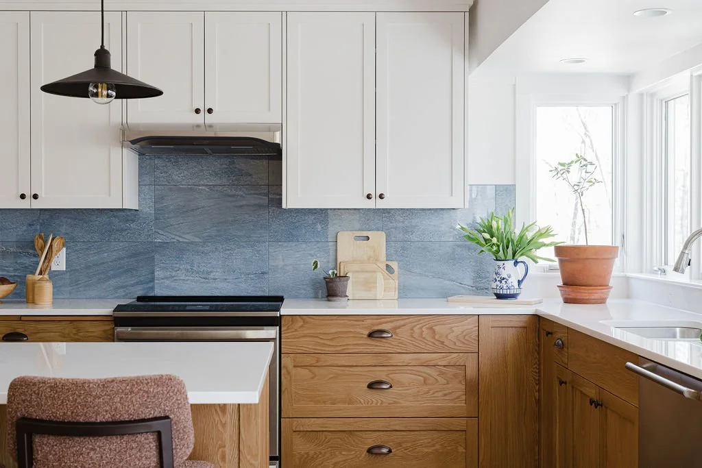 white upper cabinets and white oak lower cabinets in a custom kitchen by Sean's Cabinetry at Garvin Homes project