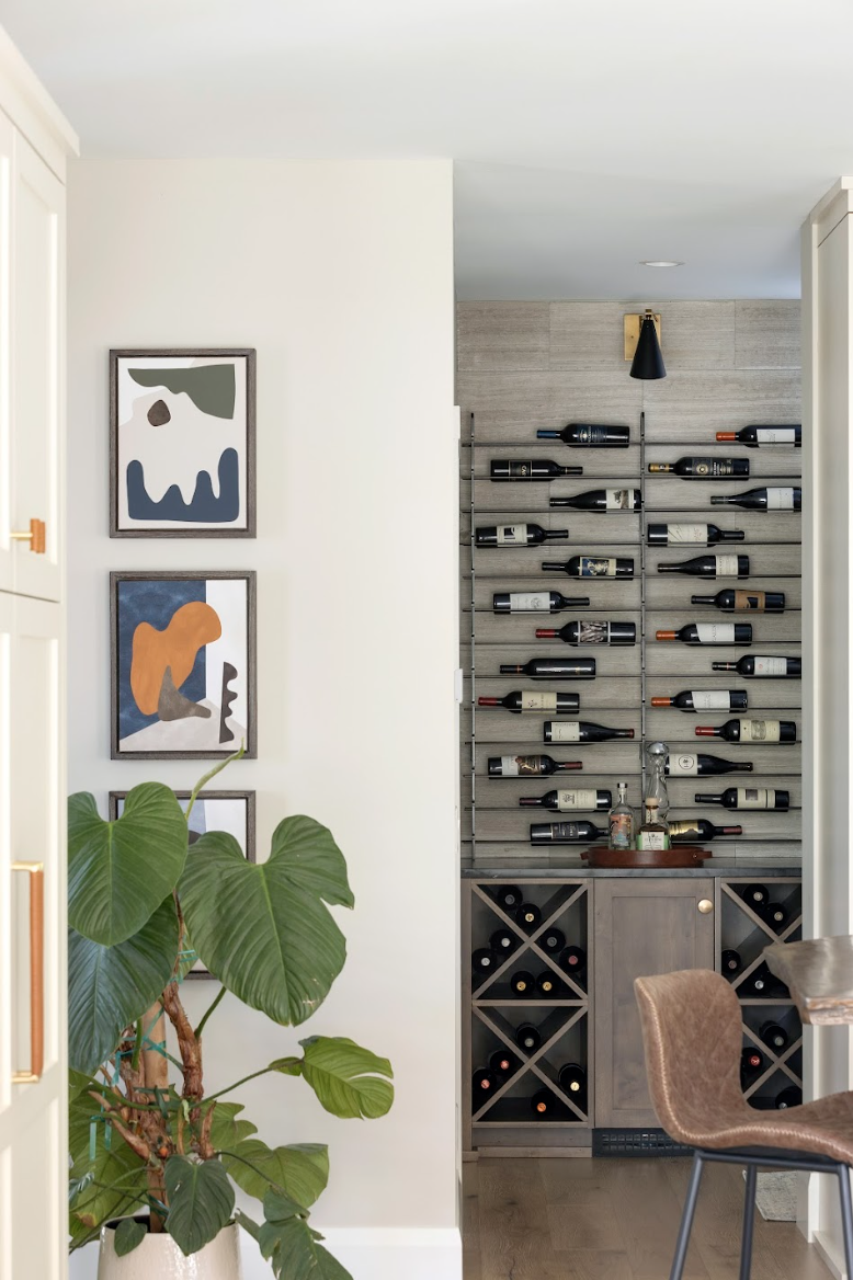 Custom built-in wine storage with floor-to-ceiling metal bottle racks and wood cabinetry.