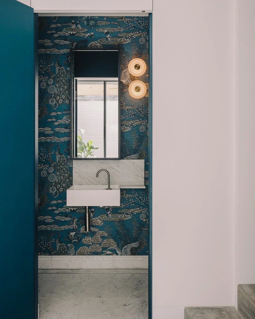 Moncur House | Powder Room

Surprise! 💙

A small space with plenty of personality.

Designed as a playful moment within the home, the powder room layers richly textured tiles, natural stone, set against a bold wallpaper backdrop. Feature wall lights