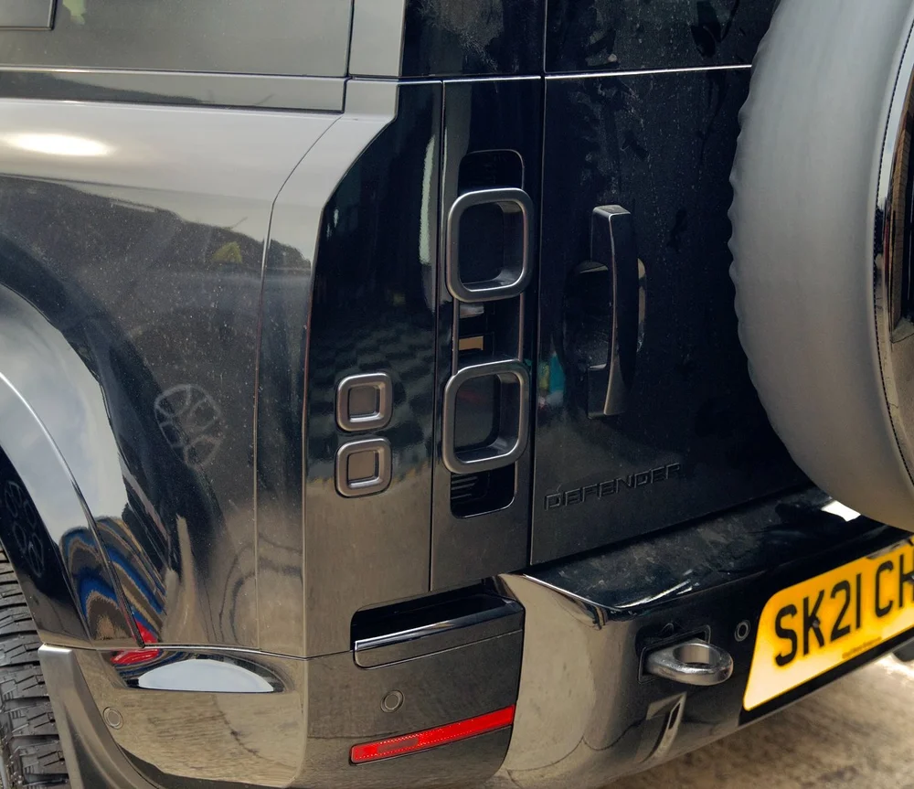 Smoked stick-on tail light covers on Defender