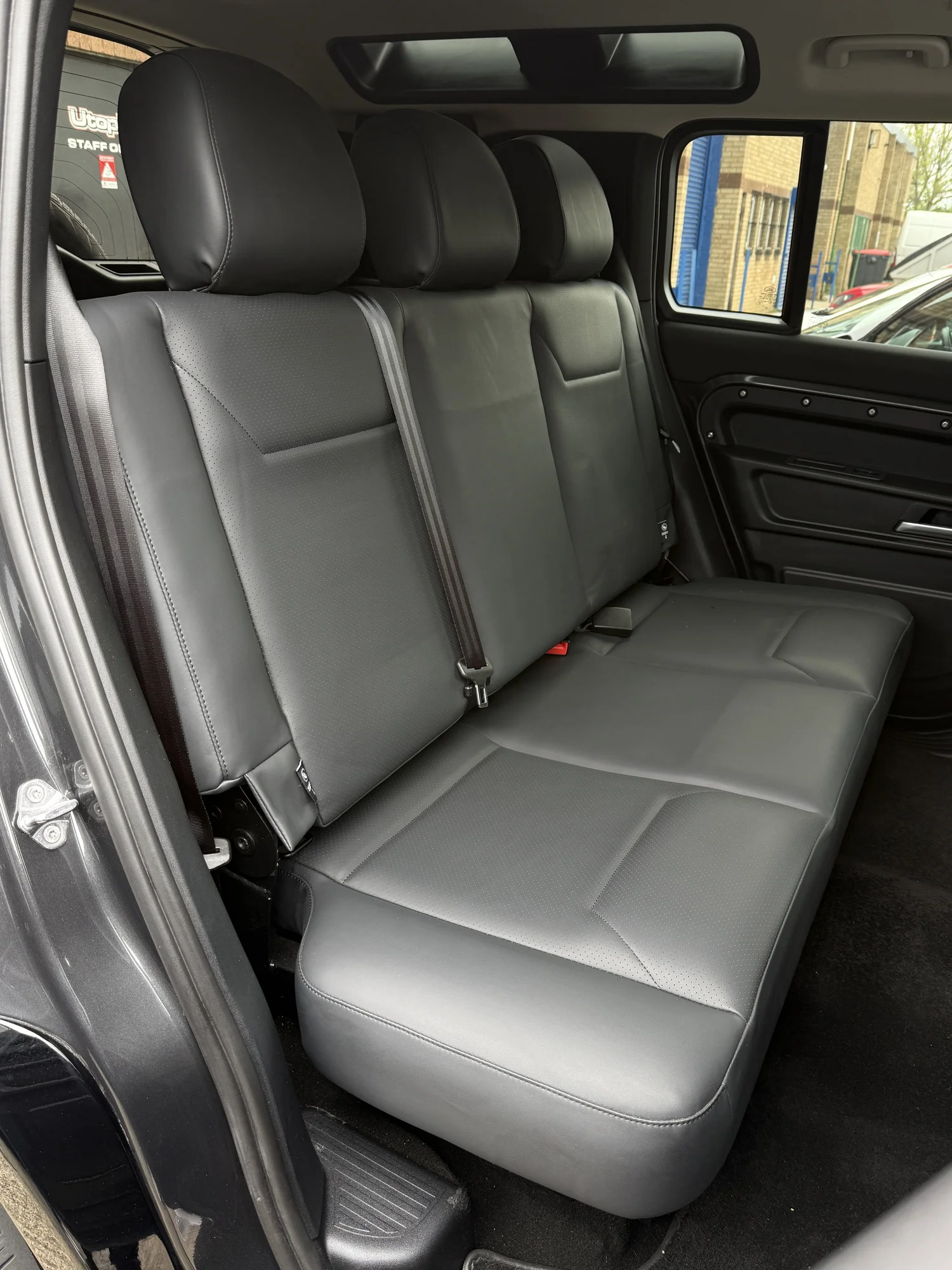Rear seats and rear door of a converted Land Rover Defender 110 at Utopia