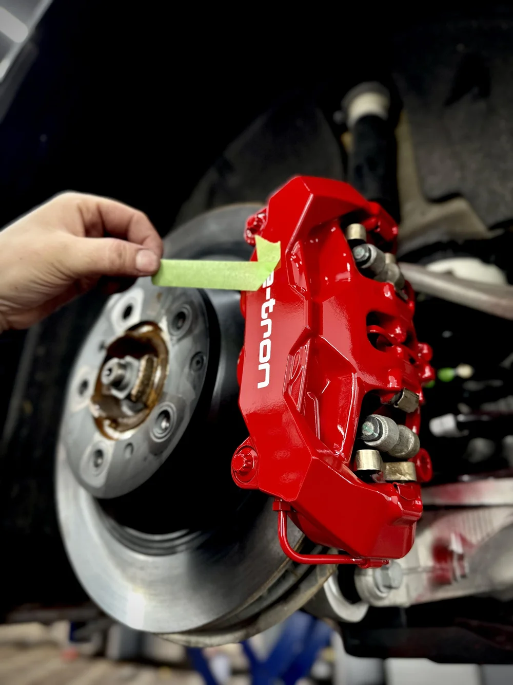 Painted brake caliper behind an alloy wheel