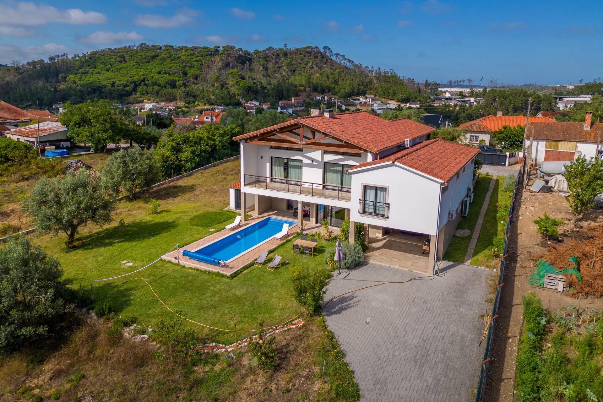 aerial view of the back of the Villa with view of the pool the garden and the long drive to park several vehicles