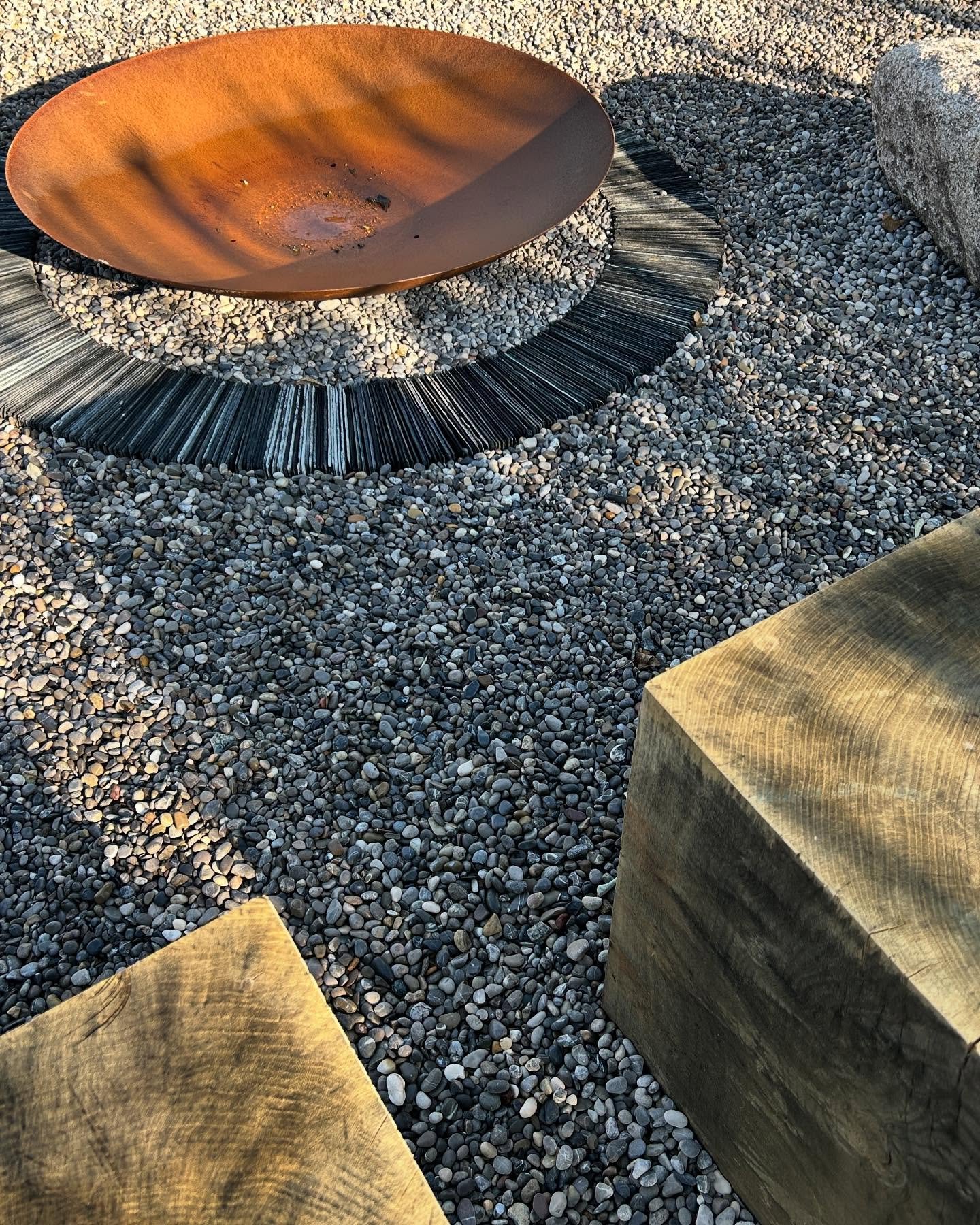 We find simple, earthy design details often work best in coastal gardens. Huge oak cubes and granite boulders make for the perfect perch around this rusty fire-bowl. A ring of reclaimed slate tiles helps to further define the space. Huge thanks to @c