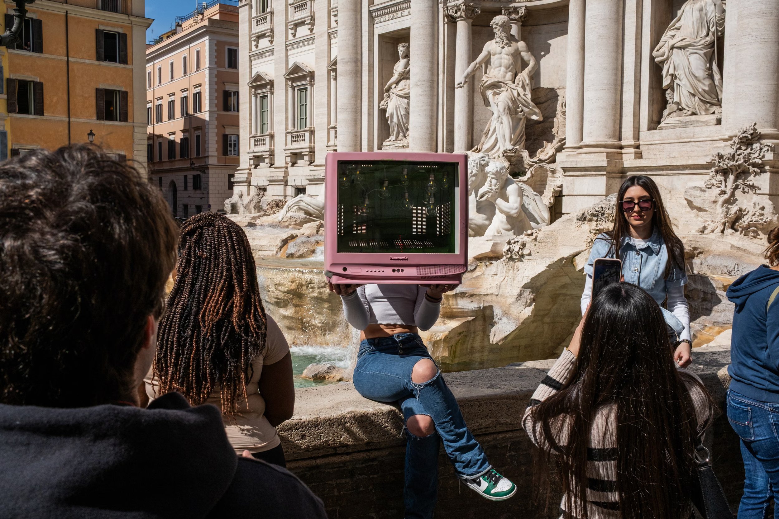 Tourists pose for photographs in front of the Trevi fountain