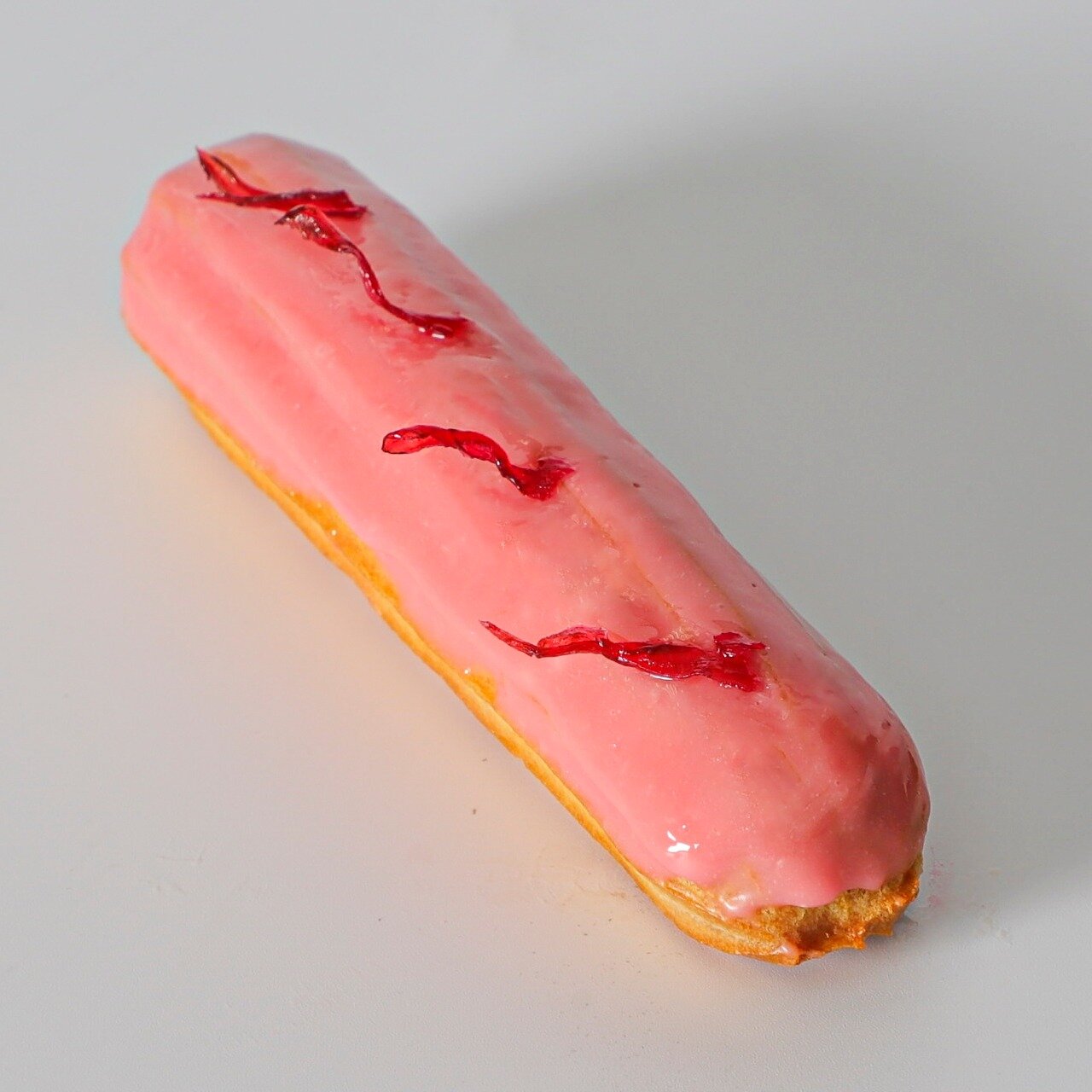 Rose Roselle Eclair
We have an elegant &eacute;clair bursting with the floral and fruity flavors of hibiscus. With a hibiscus cream filling that will leave you feeling like you're in a tropical paradise and a strawberry glaze sprinkled with candied r