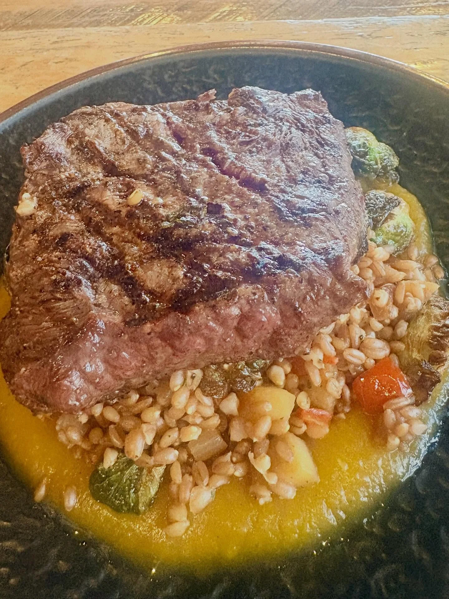 🥩 Weekend Feature Alert 🥩 
10oz Certified Flat Iron Steak, grilled and served over a curry butternut  purée. Paired with a Farro, apple, onion, bell pepper & Brussels sprout hash — this dish brings bold Southern comfort with a tou