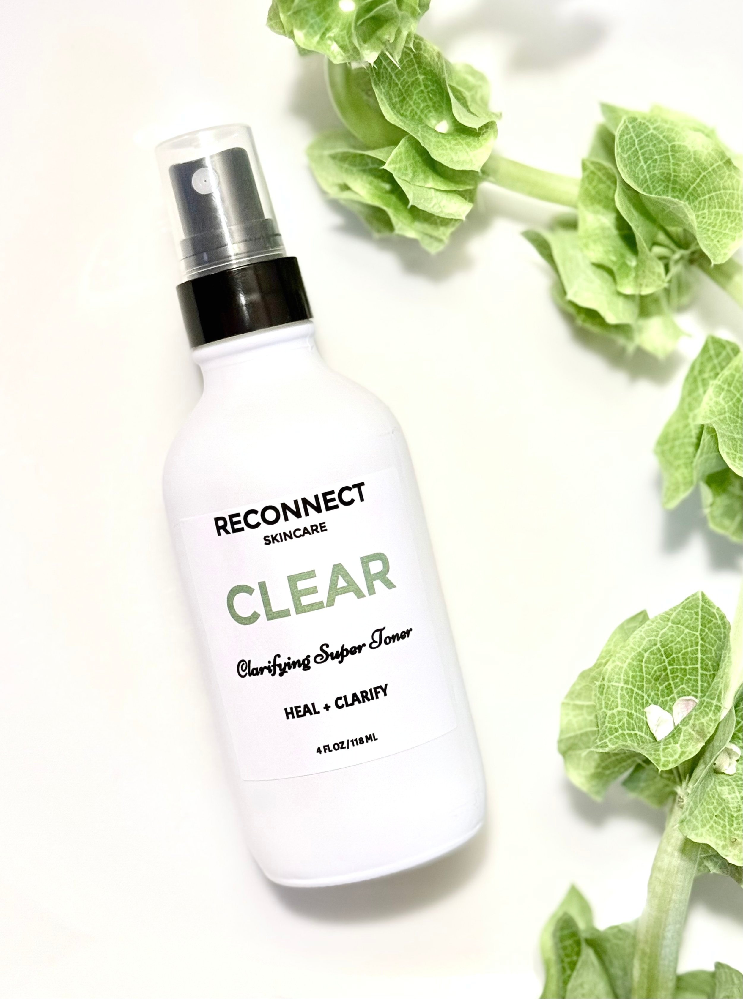 CLEAR Clarifying Toner surrounded by vibrant green foliage, showcasing its refreshing and purifying qualities.