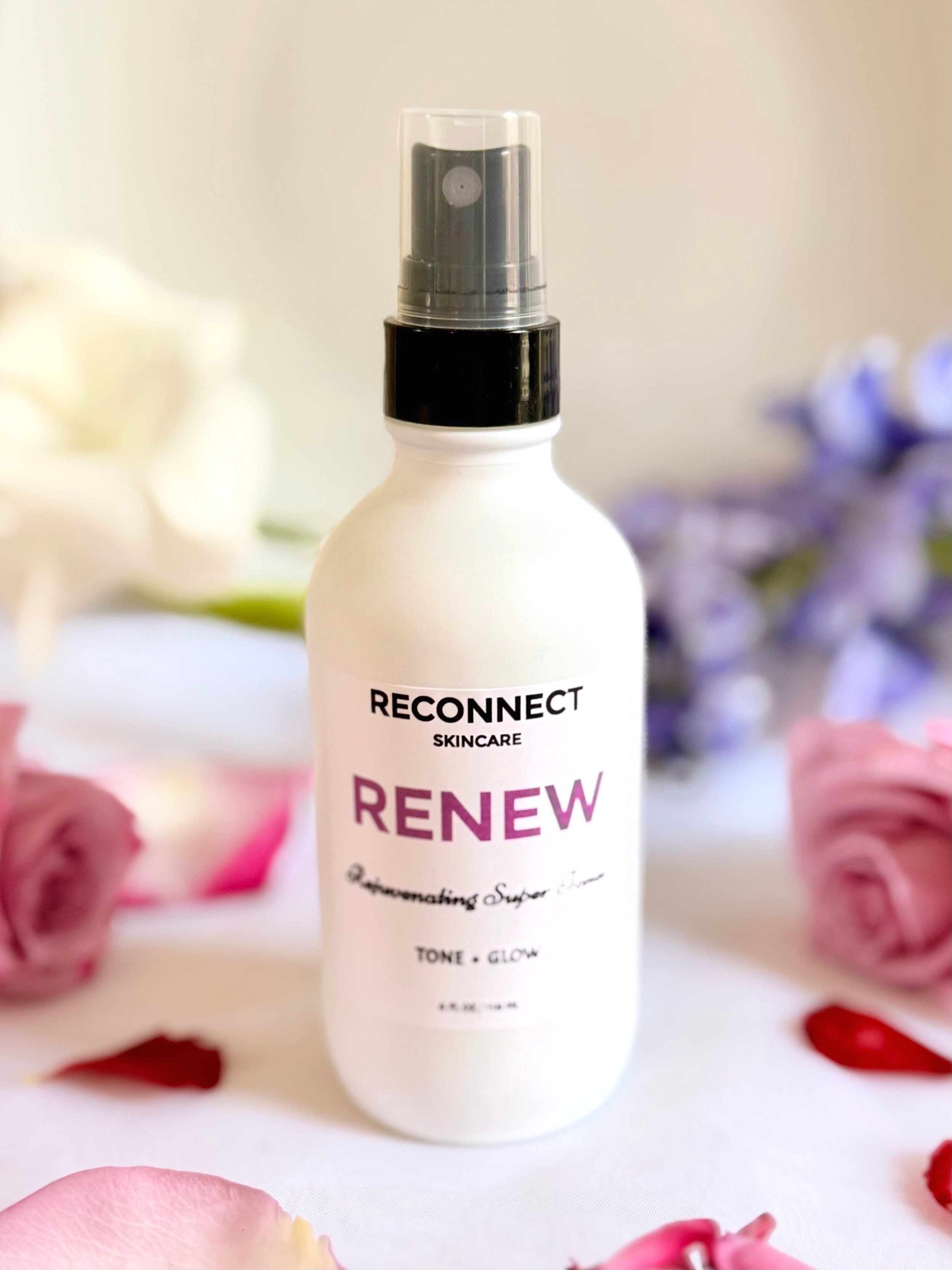 Rejuvenating Anti-Aging Super Toner surrounded by an assortment of colorful flowers, highlighting its natural, botanical formulation.