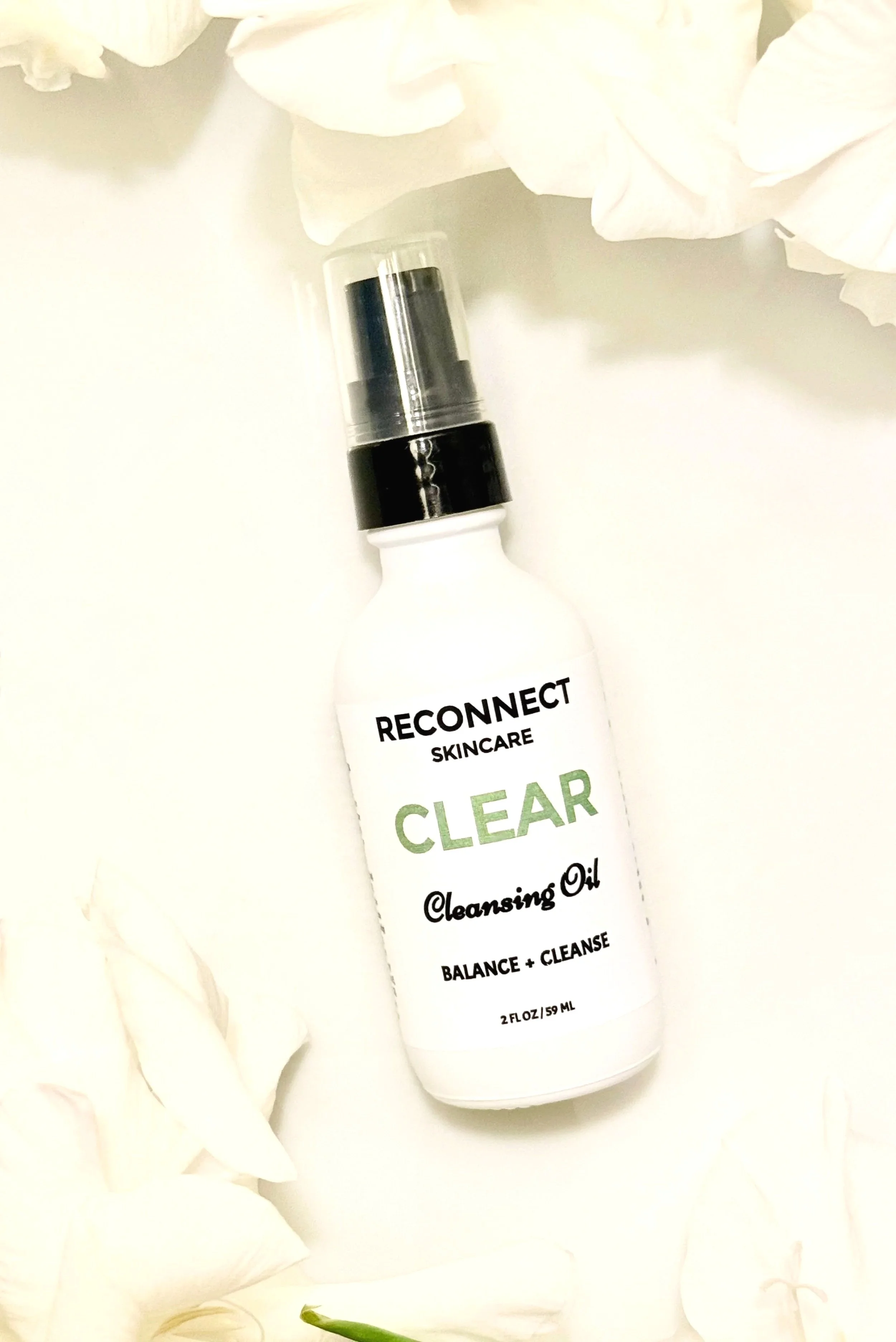 CLEAR Cleansing Oil presented in front of delicate white flowers, illustrating its purity and effectiveness for skin care.