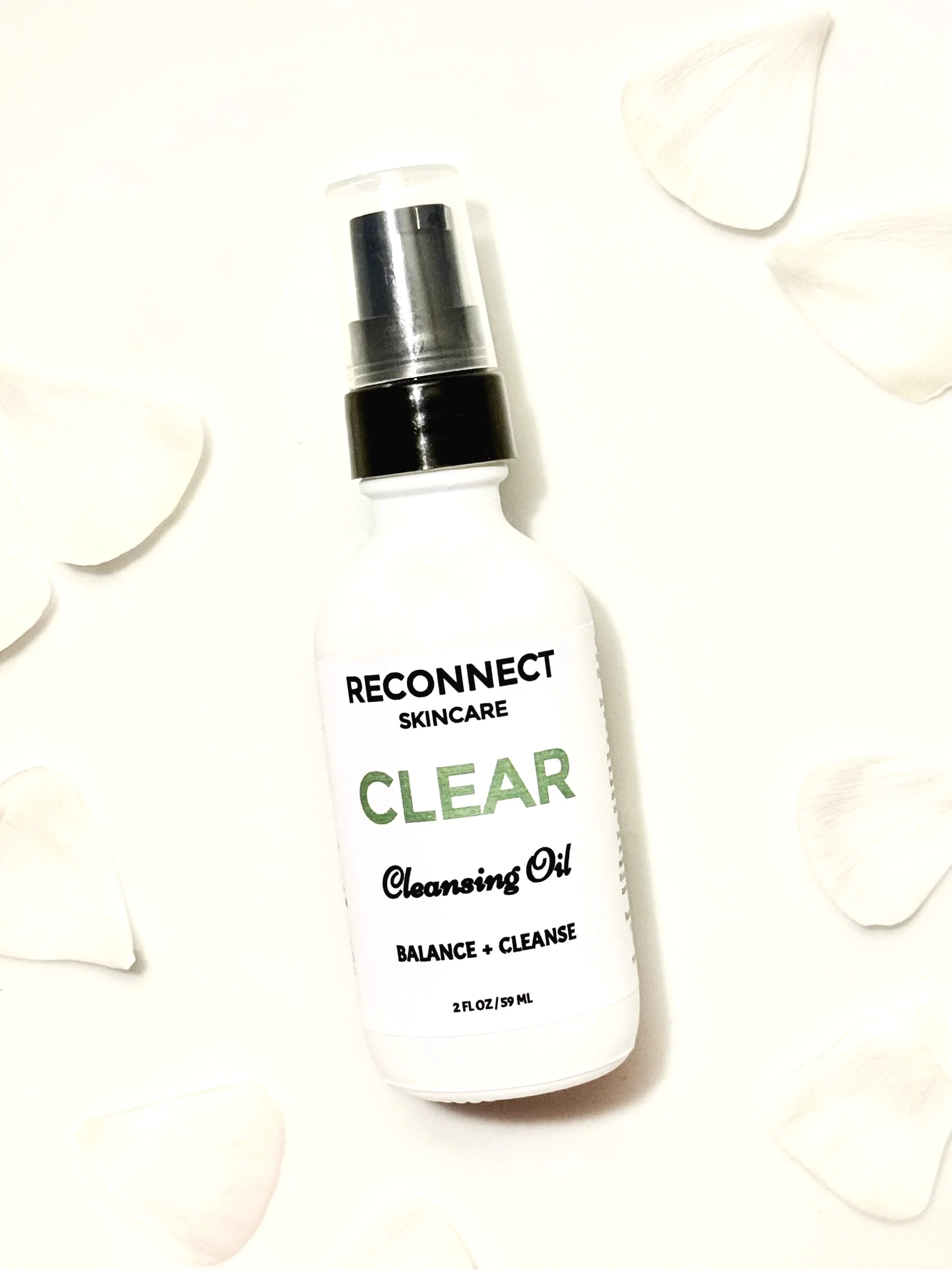 CLEAR Cleansing Oil elegantly displayed against a soft petal background, highlighting its gentle and nourishing formula.