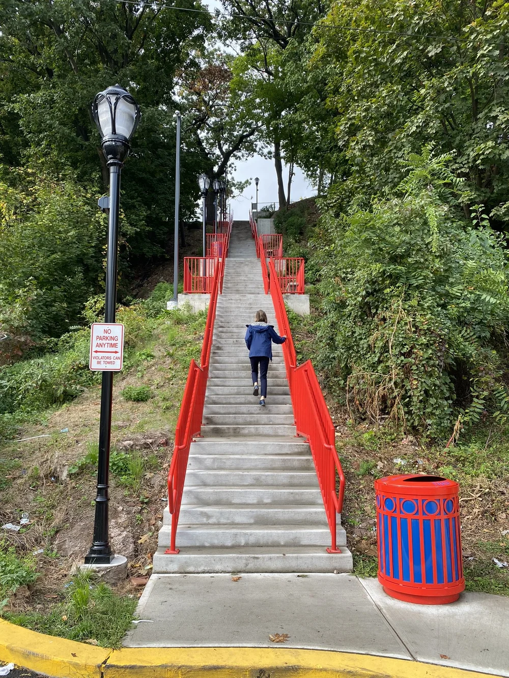 Bright red accent railings help the stairs stand out from the surrounding greenery.