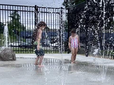 Children play in the new water spray on opening day 2024. 