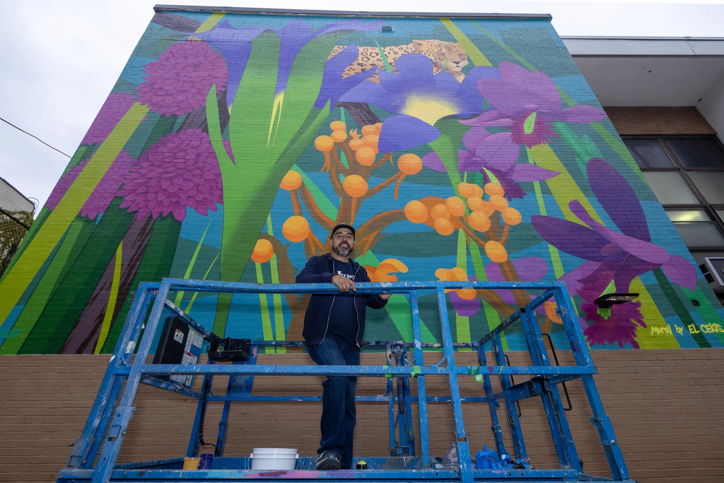 El Cekis poses with finished mural at PS12, Jersey City, NJ. Photo by Jennifer Brown
