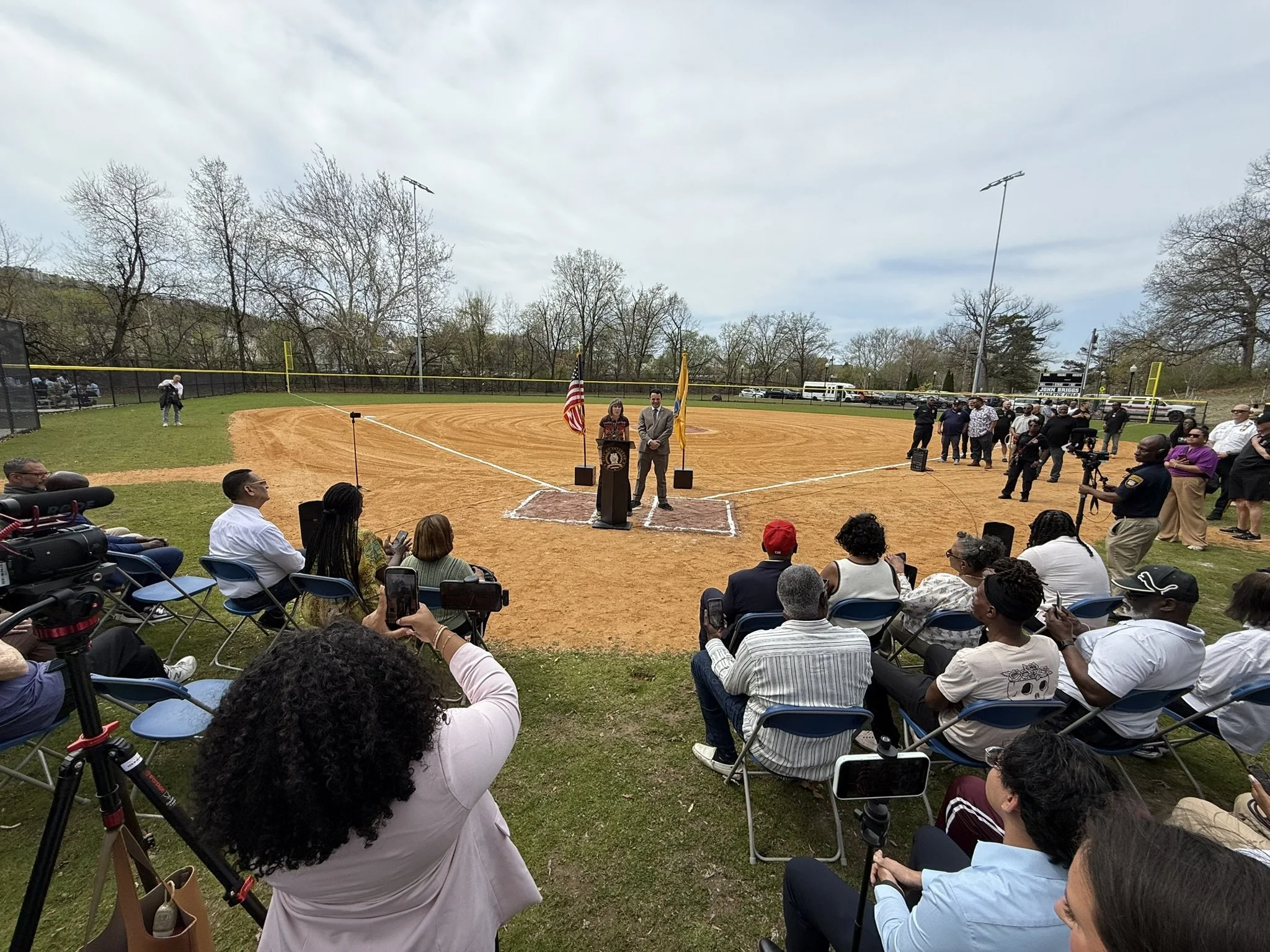 Rose addressing crowd at the field opening event.