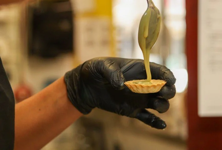 Filling white chocolate pistachio tartlets.