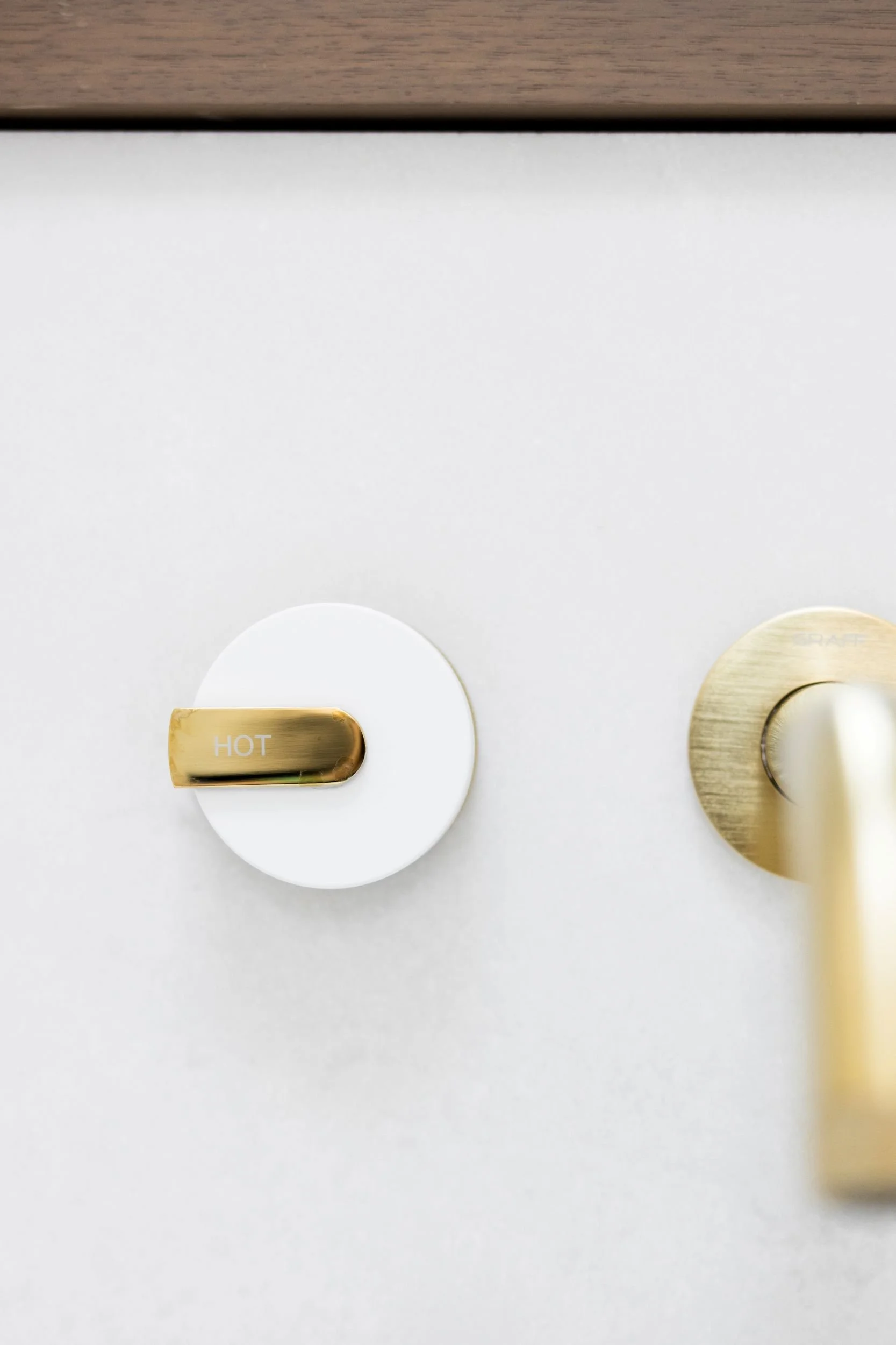 Close-up of a gold bathroom faucet and handle.