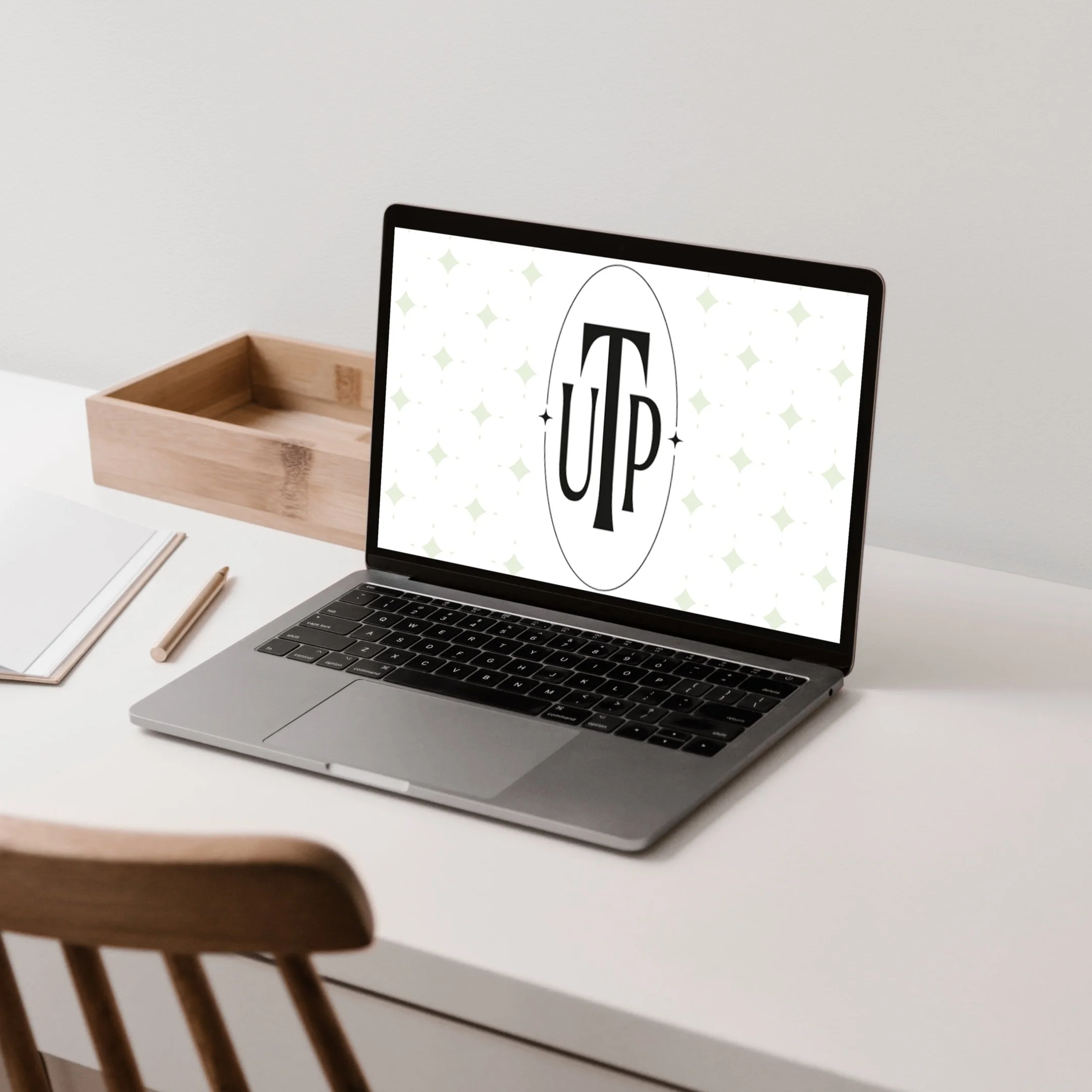 Open laptop with the Uptown Talent Partners brandmark as the screensaver— brand identity designed by Coast Road Creative, New York City for a talent acquisition agency
